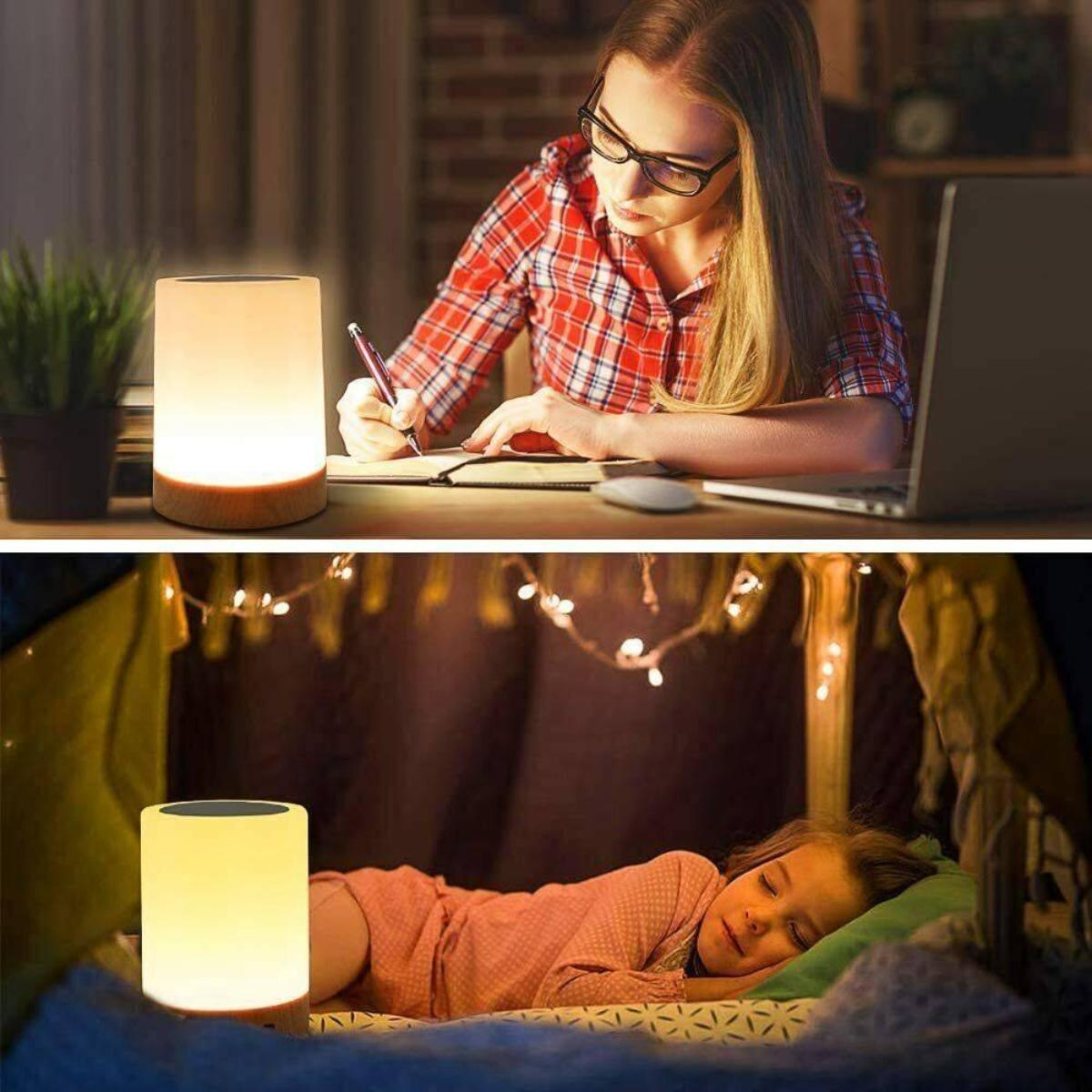 Eine schreibende Frau und ein schlafendes Mädchen in der Nähe einer leuchtenden Nachttischlampe.