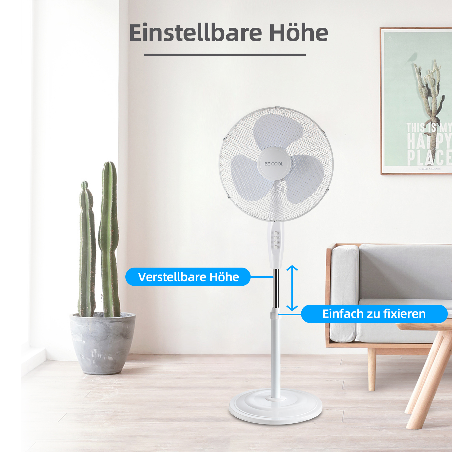 Ein weißer Standventilator ist verstellbar und steht in einem Raum mit einem Kaktus, einer Couch und einem Bild an der Wand.