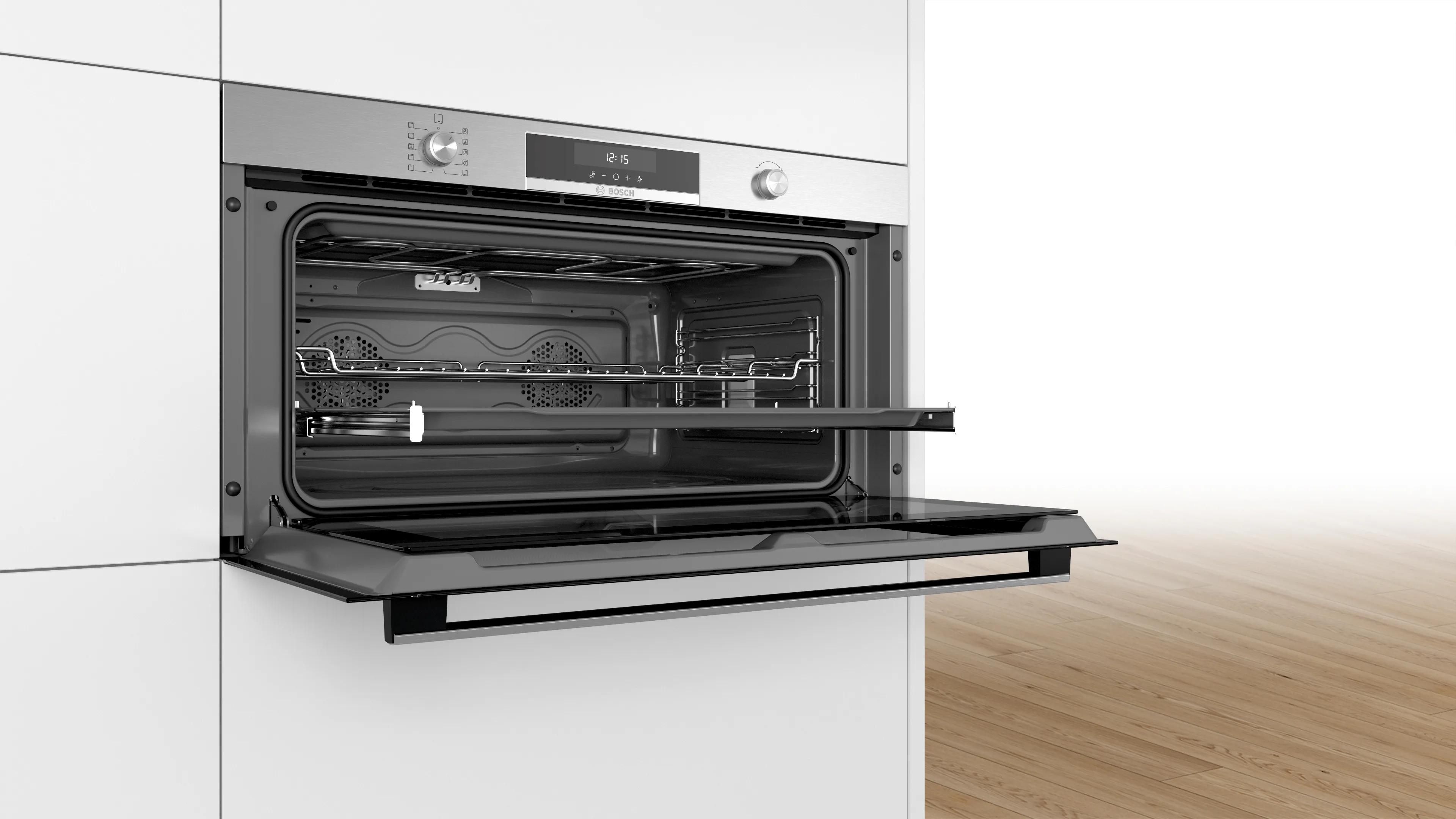 Un four Bosch installé dans une armoire de cuisine blanche, porte ouverte, montrant les grilles intérieures et un mur blanc.
