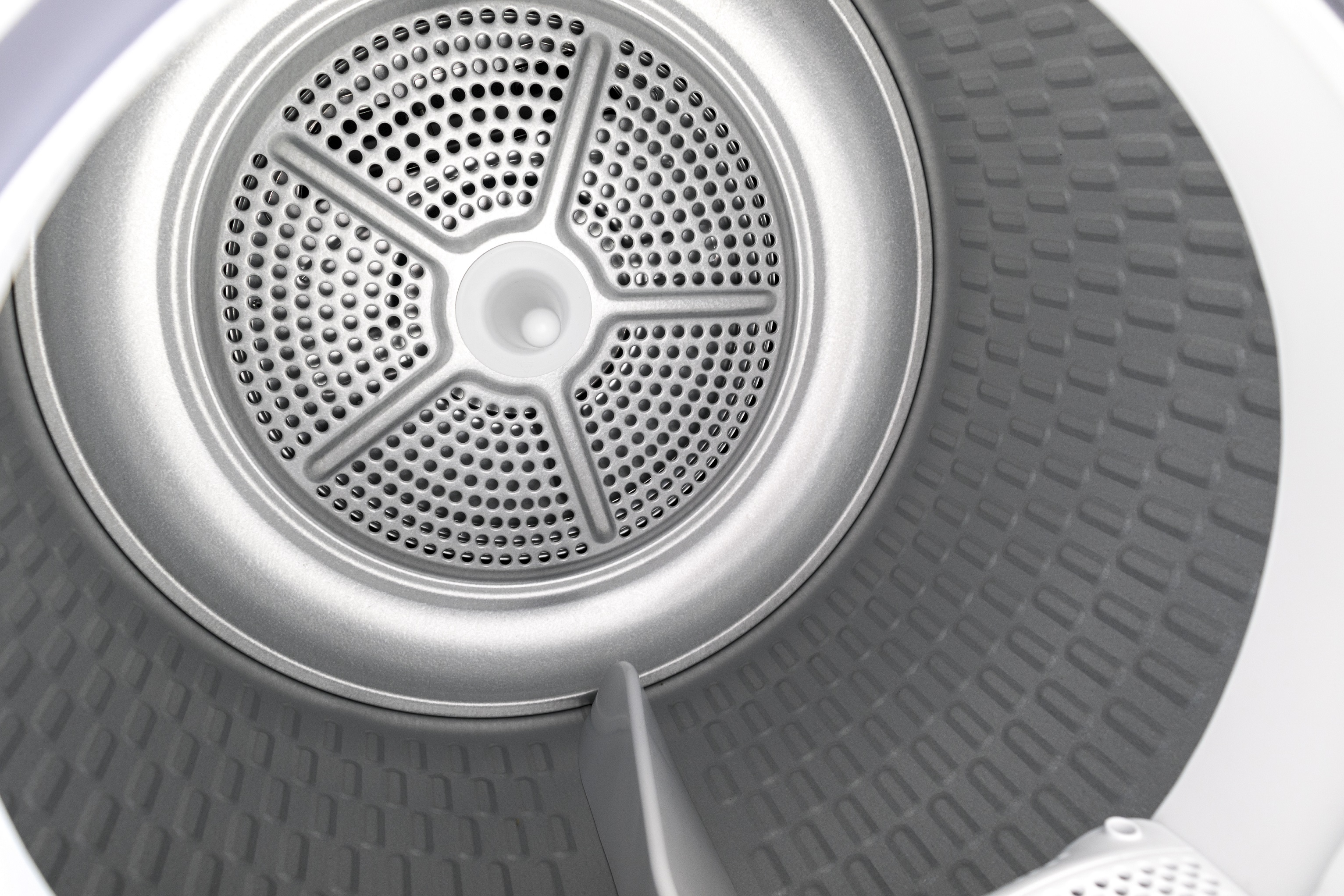 Inside a white Frizec tumble dryer drum with a metal fan and patterned walls.
