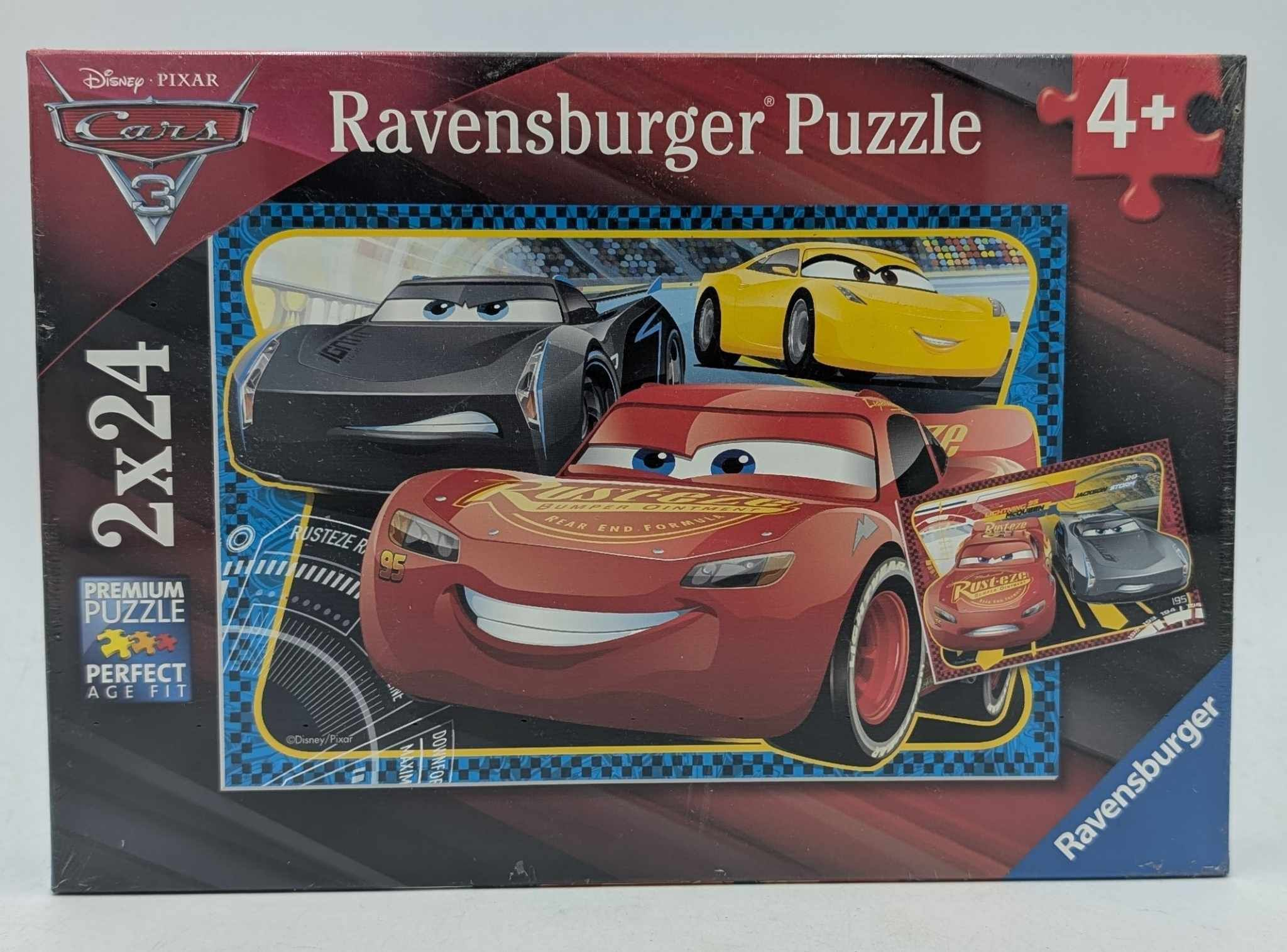 Puzzledose mit Cars 3-Charakteren: Roter Lightning McQueen, schwarze und gelbe Autos. "Ravensburger Puzzle" steht drauf.