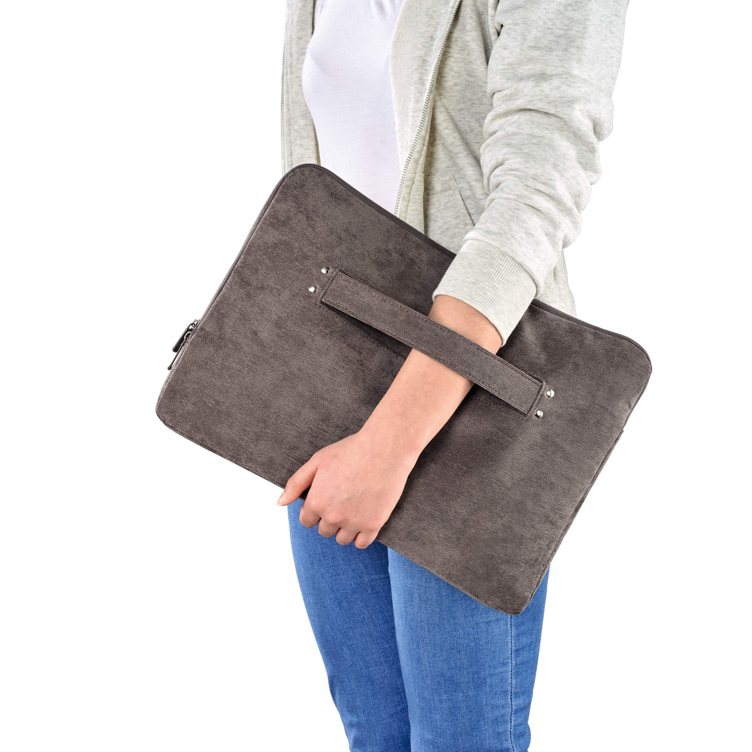 Person hält eine graue Laptop-Hülle. Weißes Hemd und blaue Jeans sind sichtbar. Weißer Hintergrund.
