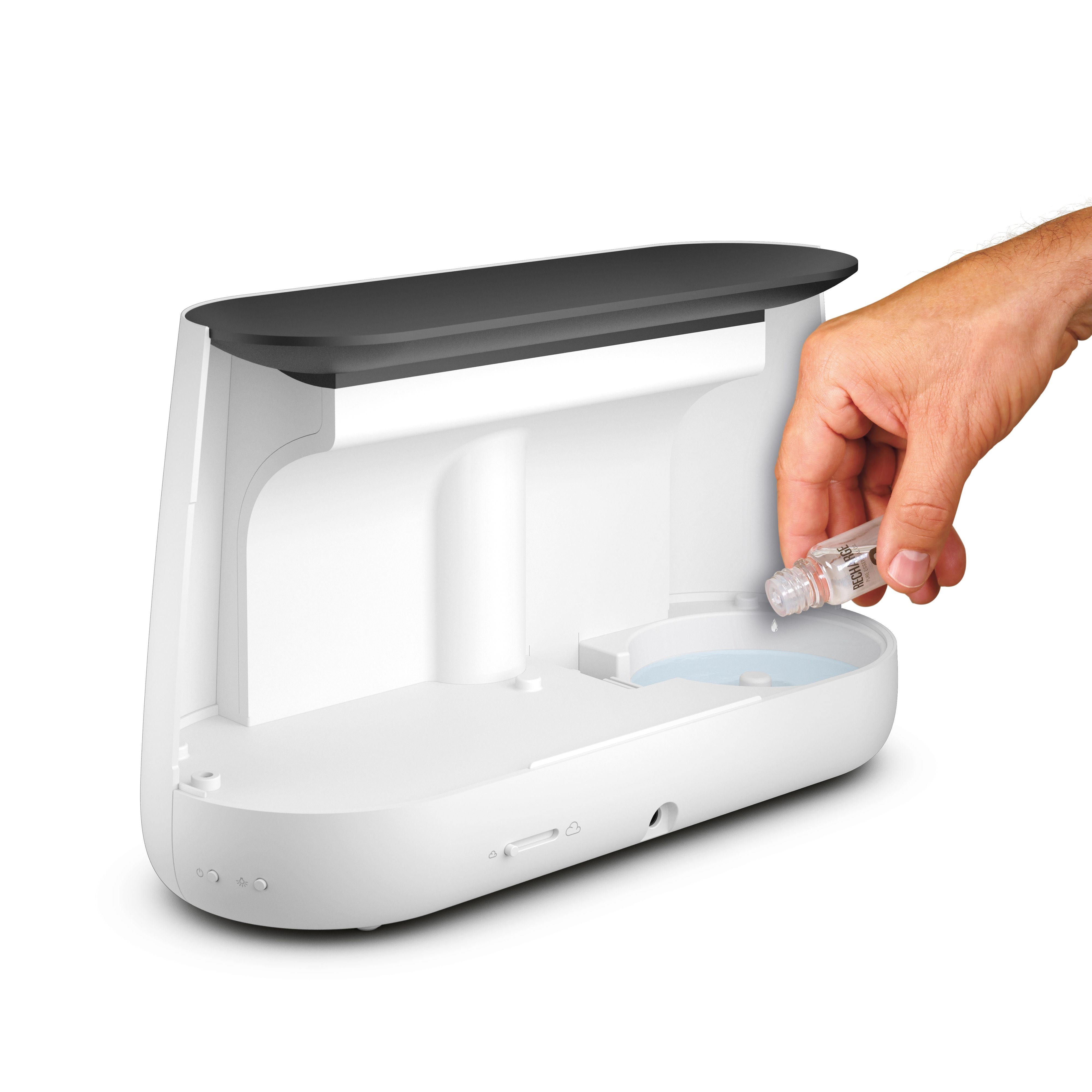 Ręka wlewa płyn z butelki do podstawy oczyszczacza powietrza.