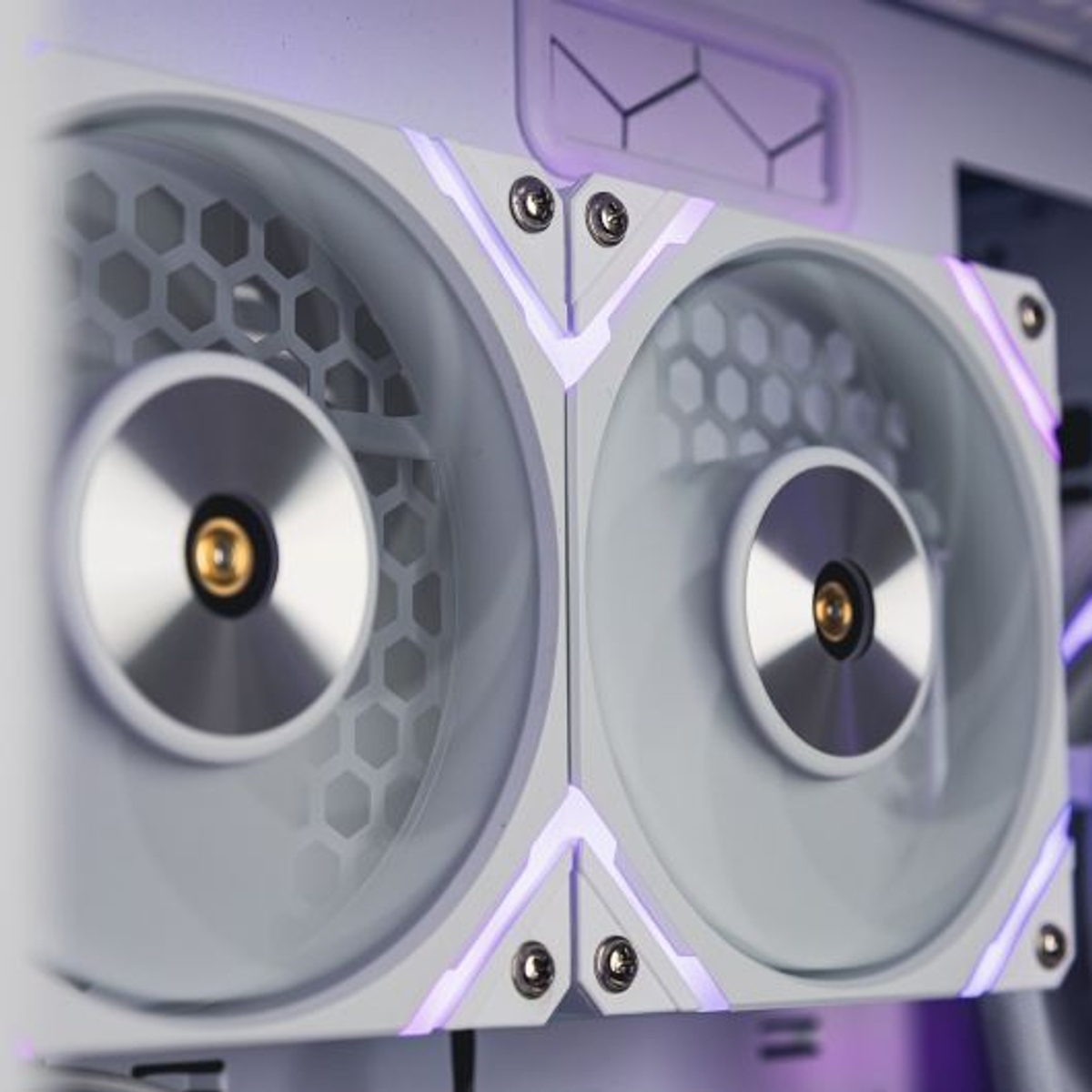 Primer plano de un enfriador líquido de computadora blanco con dos ventiladores. Iluminación LED púrpura y diseño hexagonal del ventilador.