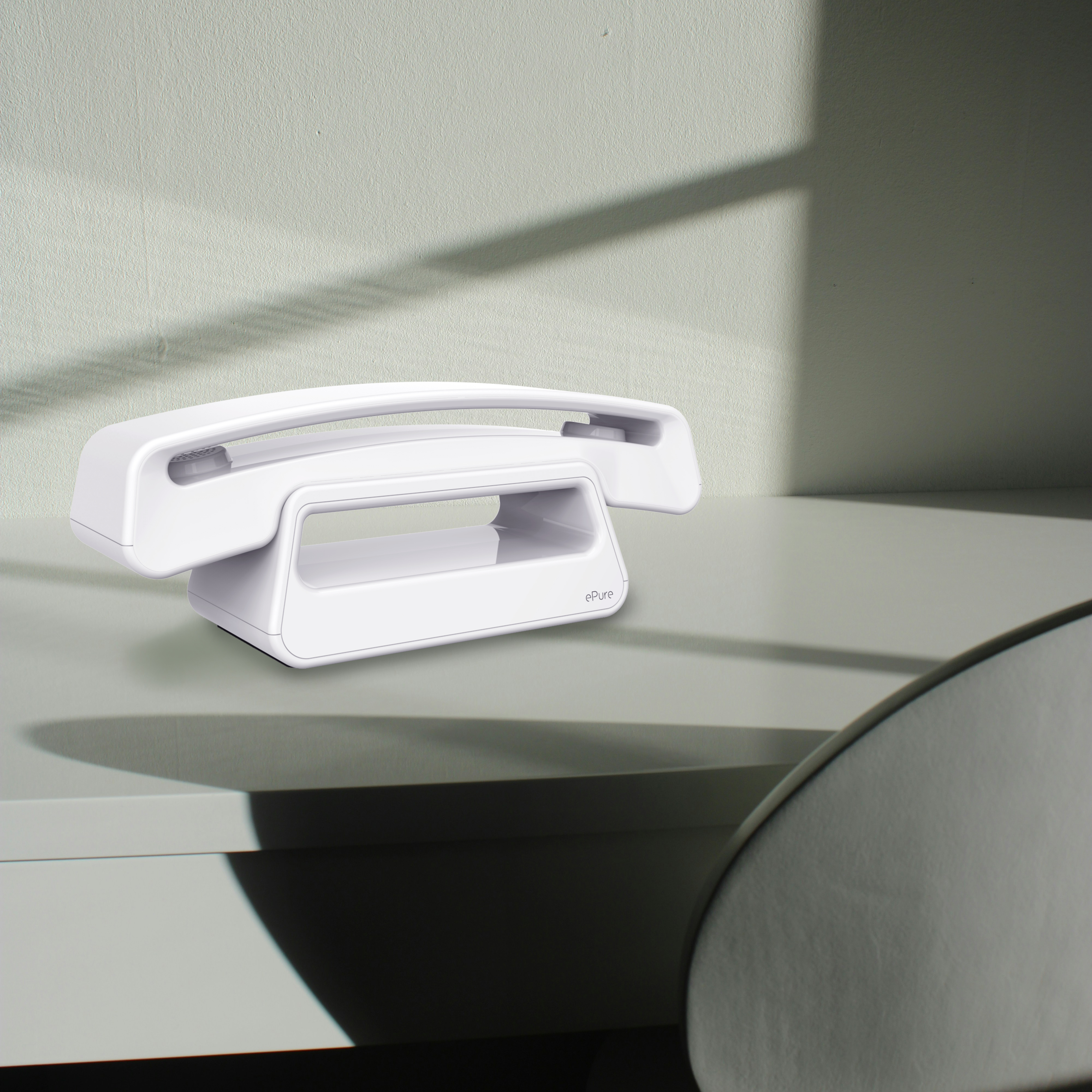 Téléphone sans fil blanc sur un bureau vert clair, avec une ombre et une chaise.