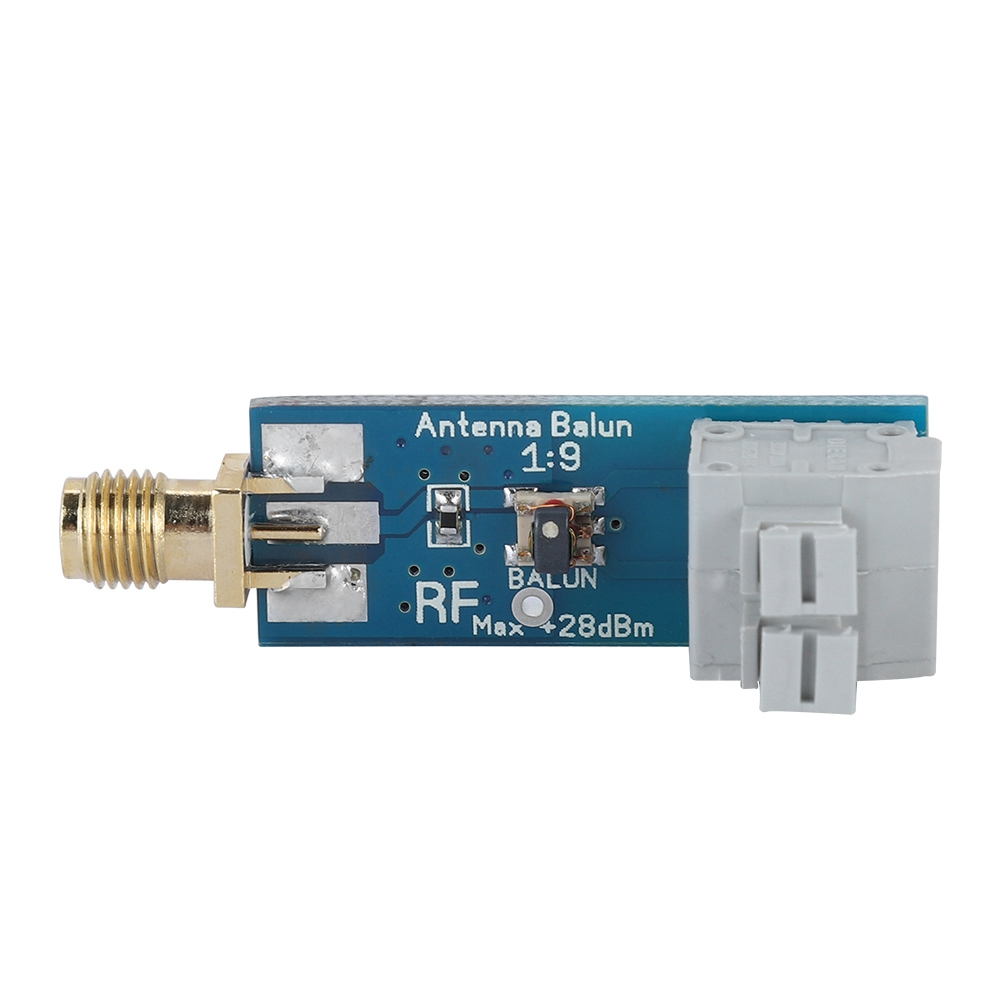 Eine blaue Leiterplatte mit Goldstecker und einem grauen Stecker. Es steht Antenna Balun 1:9.