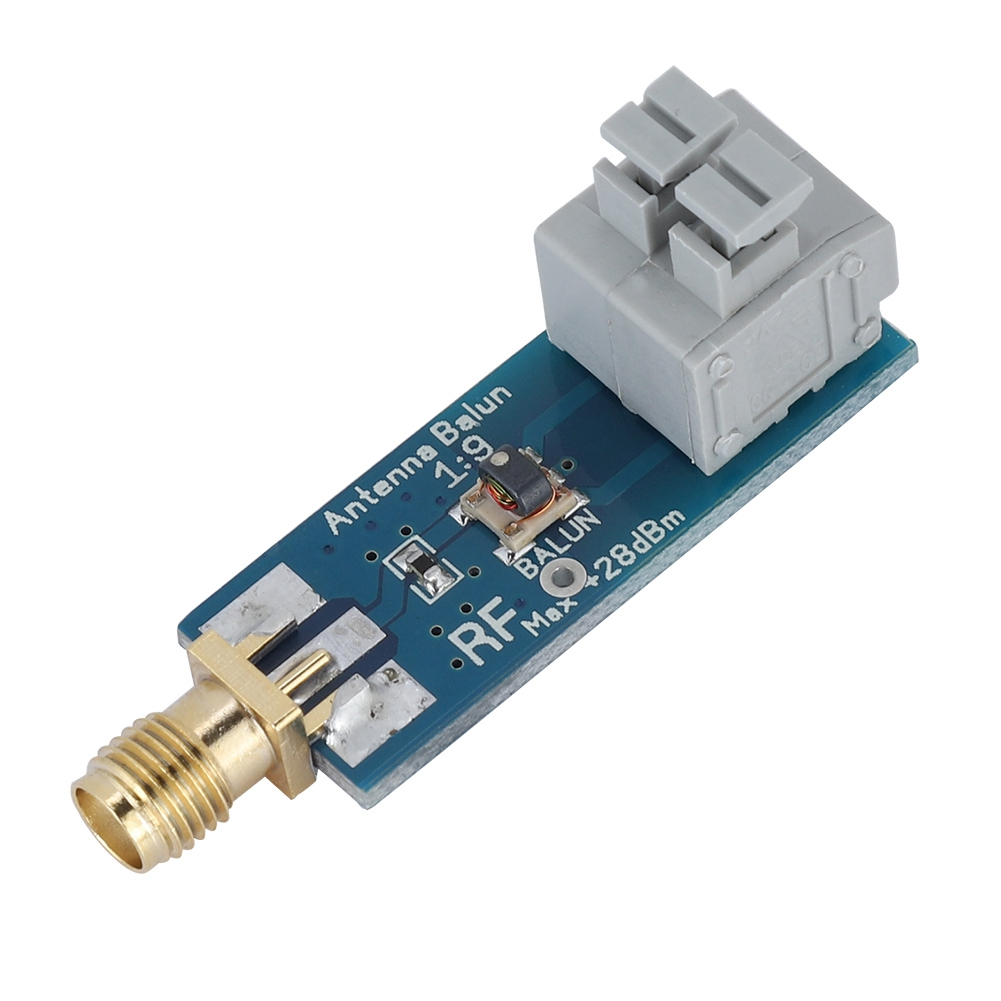 Ein blauer und goldener Antennen-Balun mit einem grauen Stecker.