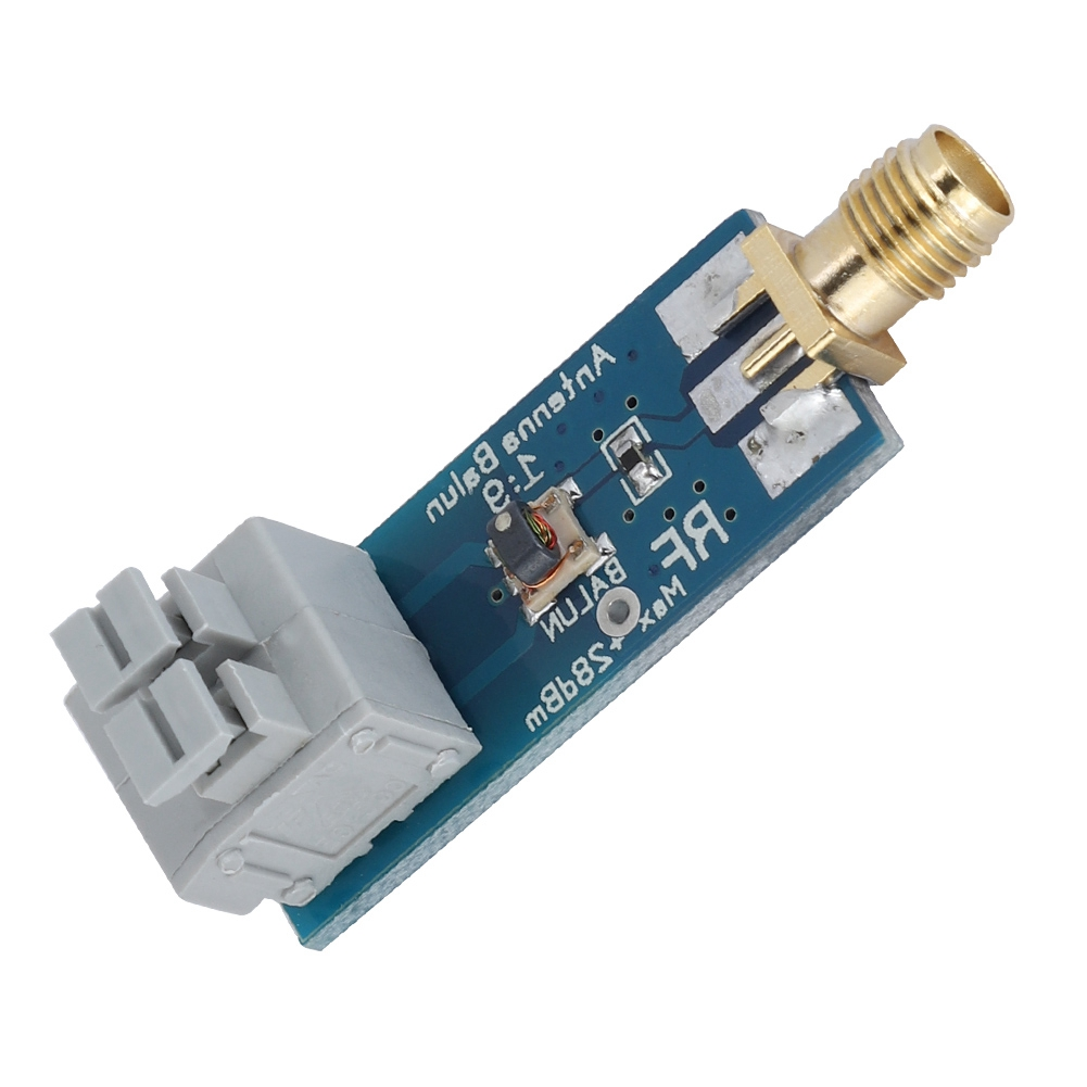 Eine blaue Platine mit einem Goldstecker und einem grauen Stecker. Auf der Platine steht Antenna Balun 1:9.