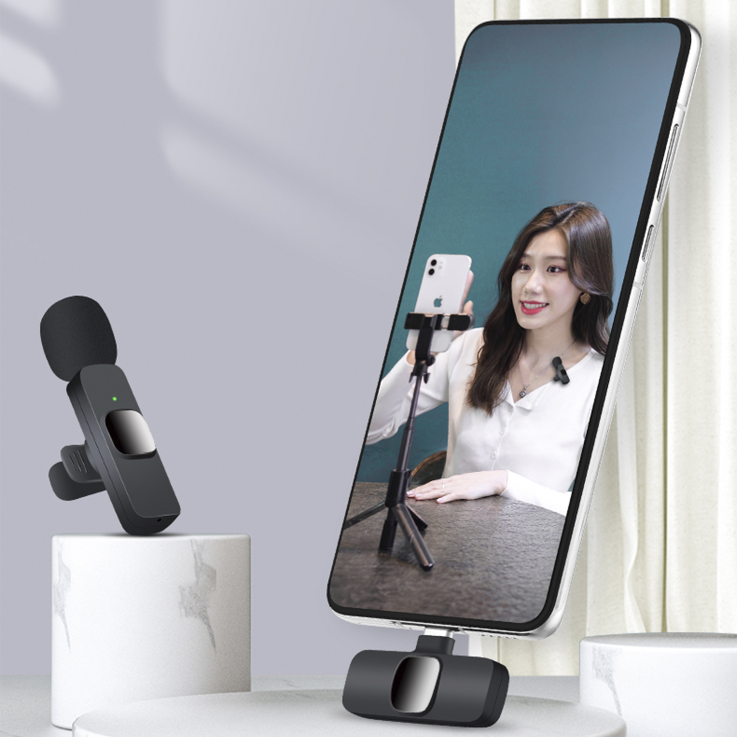 Donna sullo schermo dello smartphone, che registra un video. Microfono e supporto per telefono davanti.