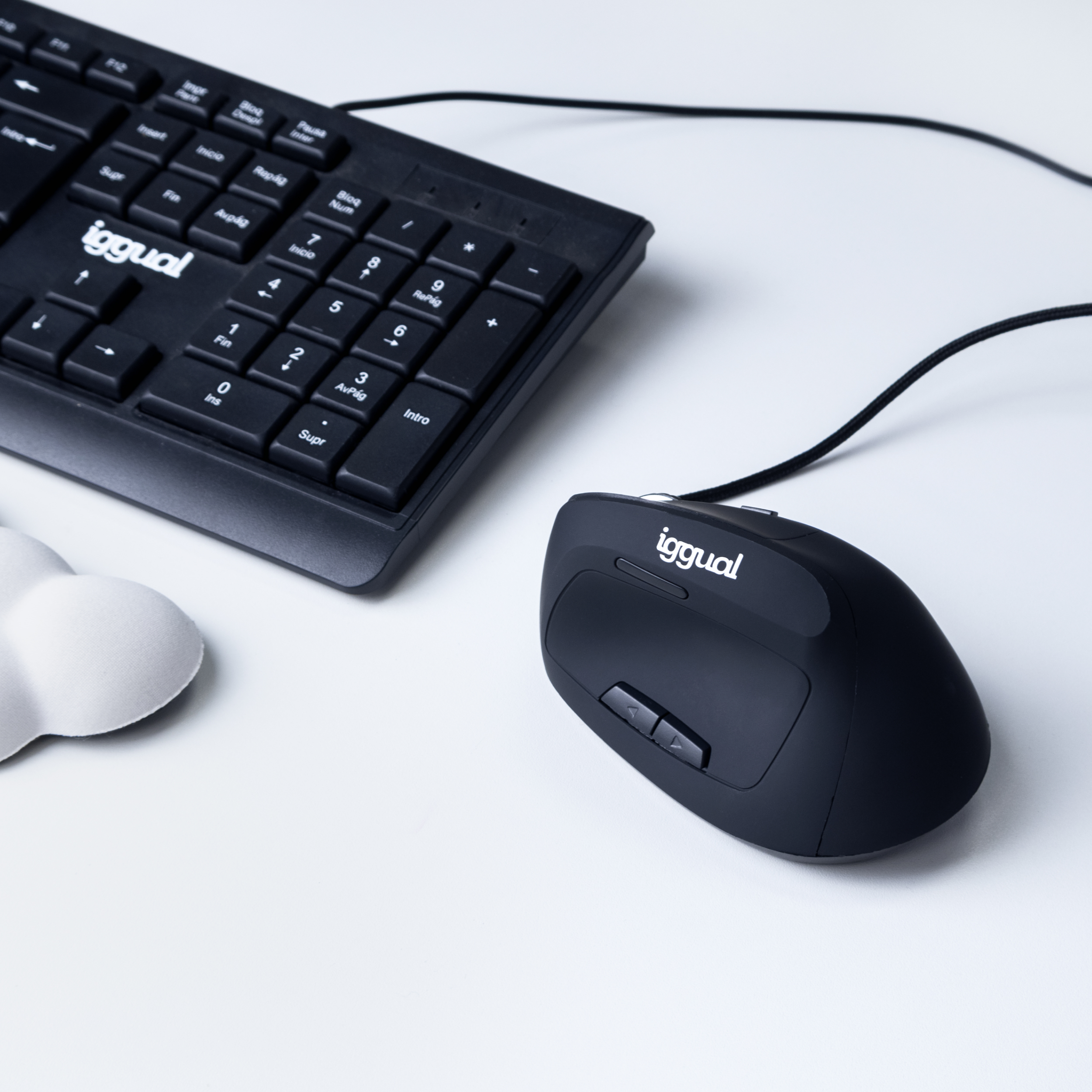 Czarna mysz i czarna klawiatura na białej powierzchni. Mysz jest obok klawiatury.