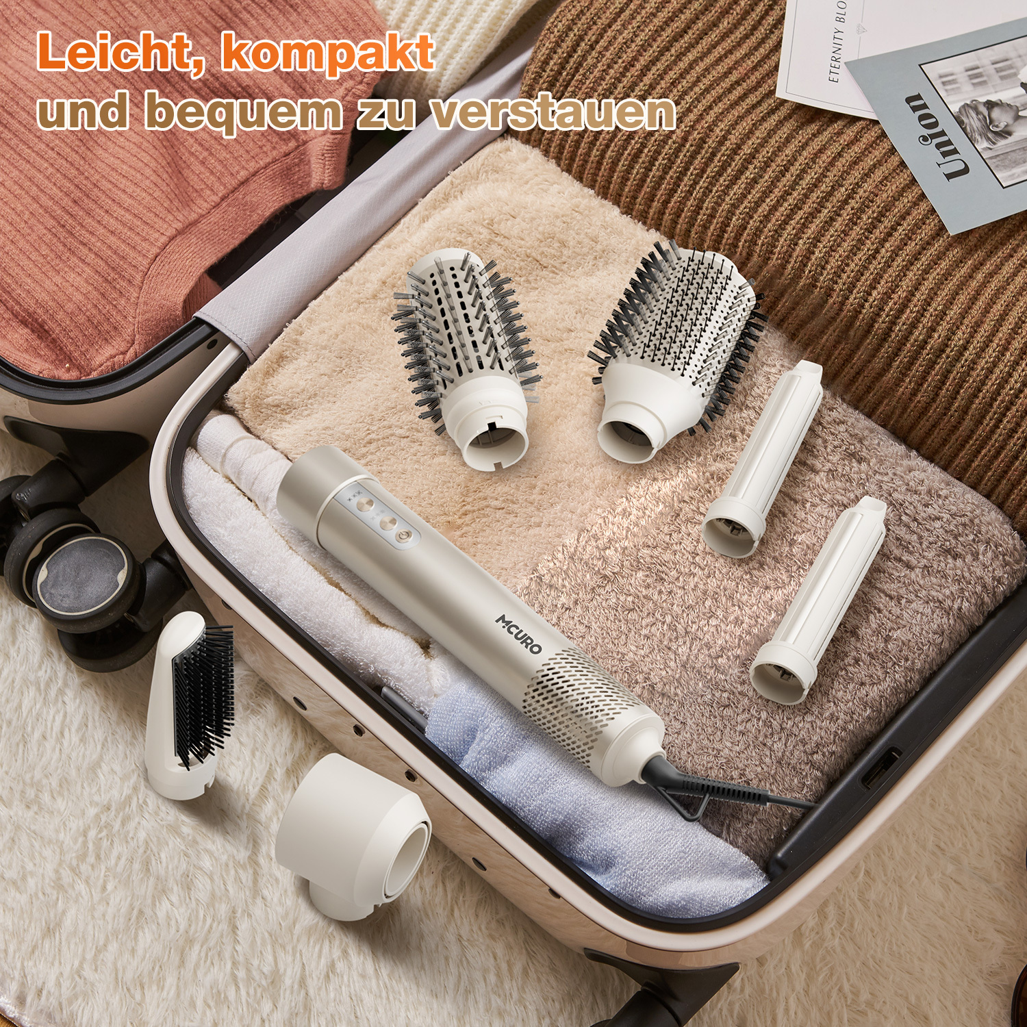 Haarstyler mit Aufsätzen in offenem Koffer. Beige und weiße Zubehörteile auf flauschiger, beiger Oberfläche. Text: 'Leicht zu verstauen'.