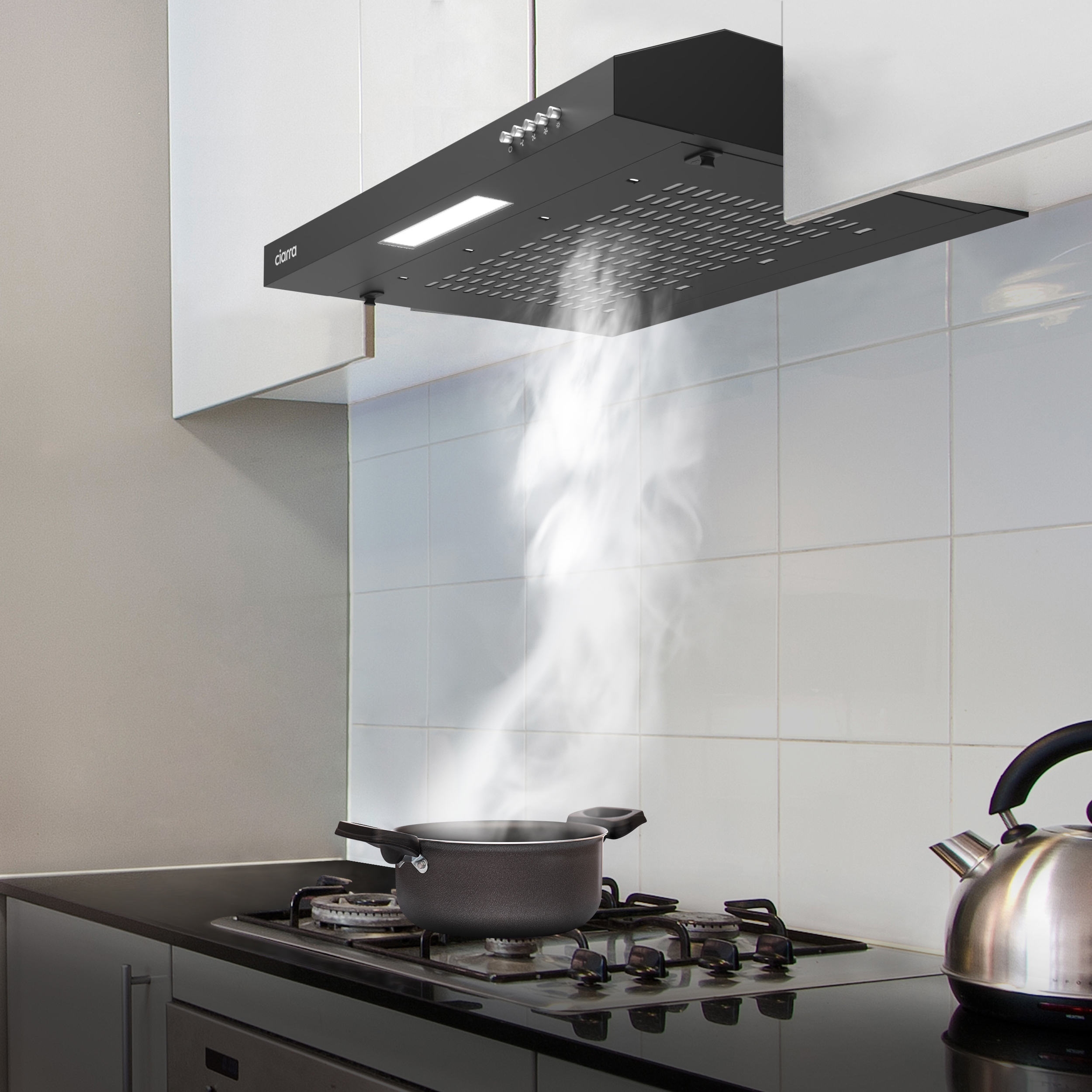 Hotte aspirante au-dessus d'une cuisinière avec une casserole d'eau bouillante, dégageant de la vapeur. Fond de carreaux blancs.