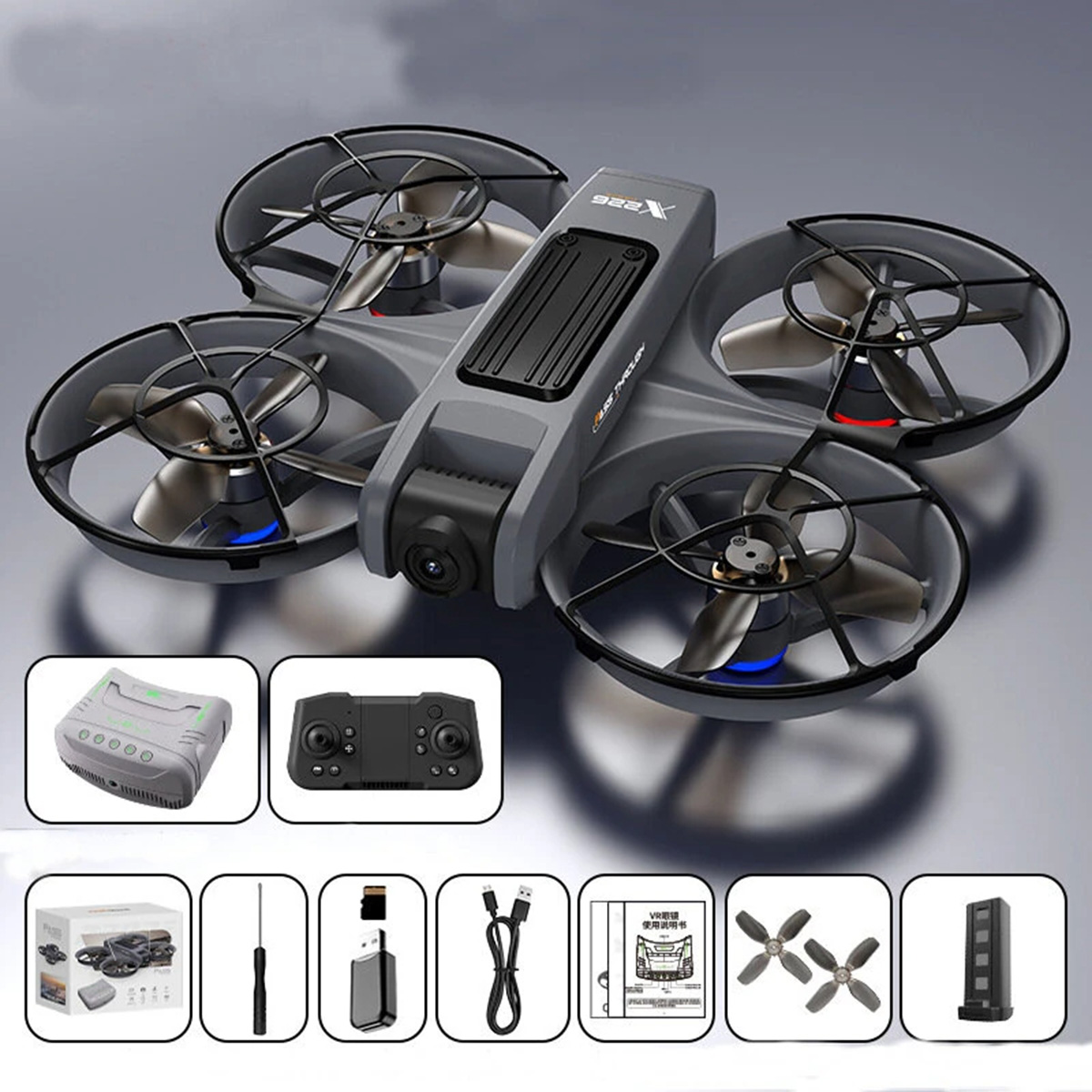 Dron gris con cuatro hélices. Accesorios adicionales visibles en el fondo.