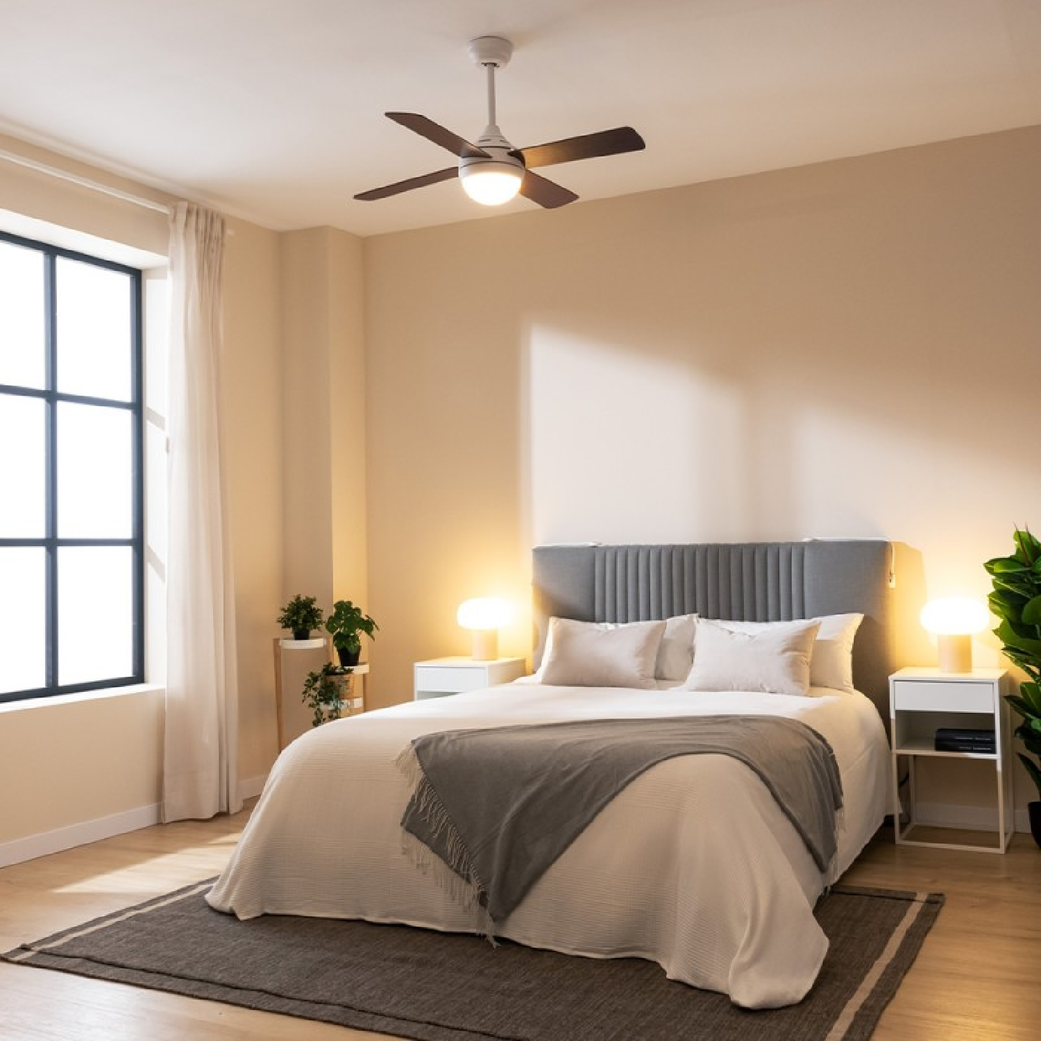 Sypialnia z łóżkiem, wentylatorem sufitowym i dwoma stolikami nocnymi z lampami. Okno po lewej stronie.