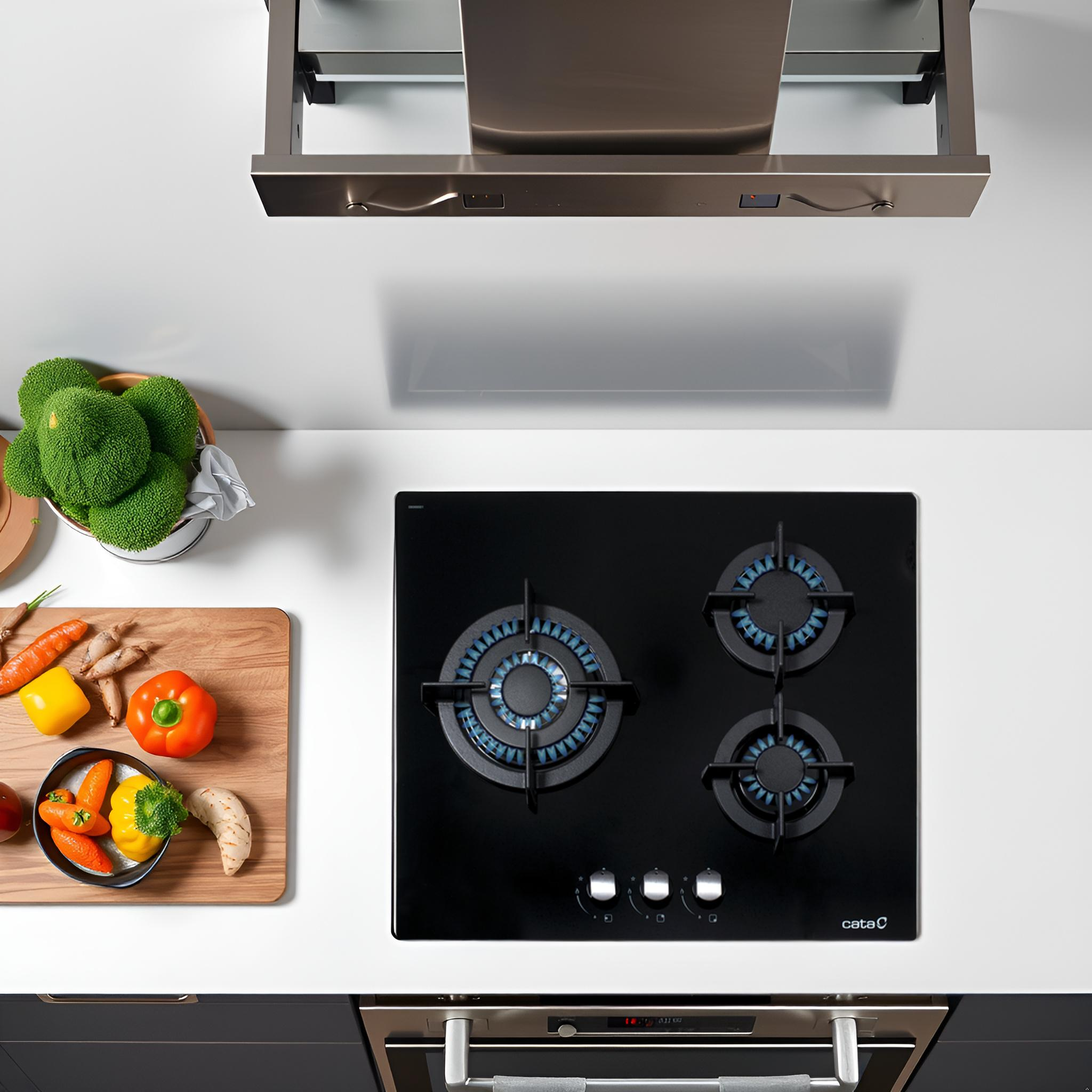 Vista cenital de una encimera de cocina con placa y verduras. Combinación de colores blanco y negro. Cocina moderna.