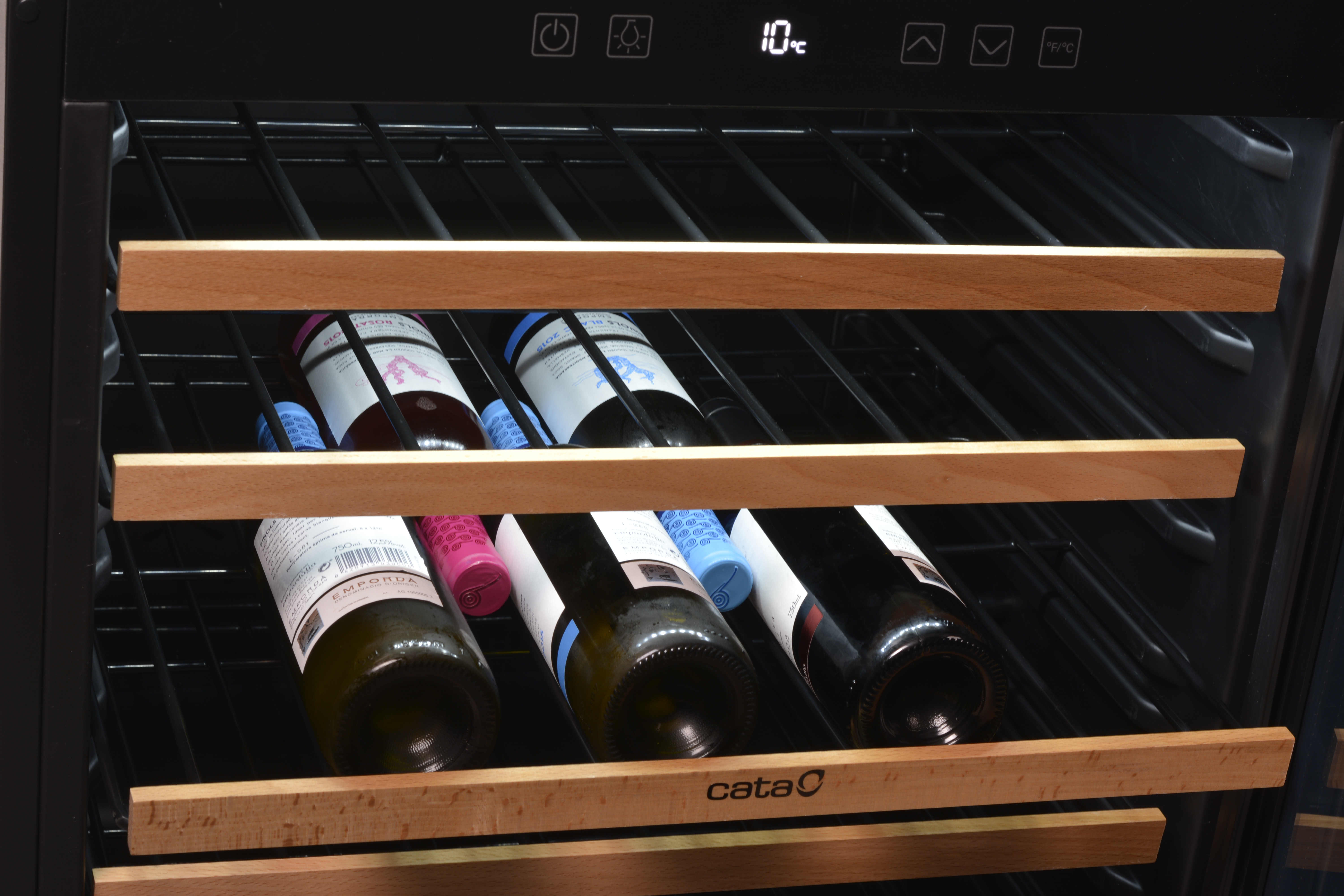 Chłodziarka do wina z drewnianymi półkami, na których znajdują się trzy butelki wina z kolorowymi korkami.