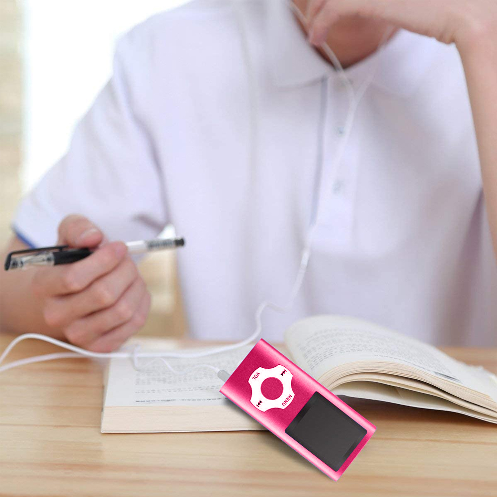Eine Person benutzt einen rosa MP3-Player mit Kopfhörern, während sie ein Buch liest. Ein Stift liegt auf dem offenen Buch.