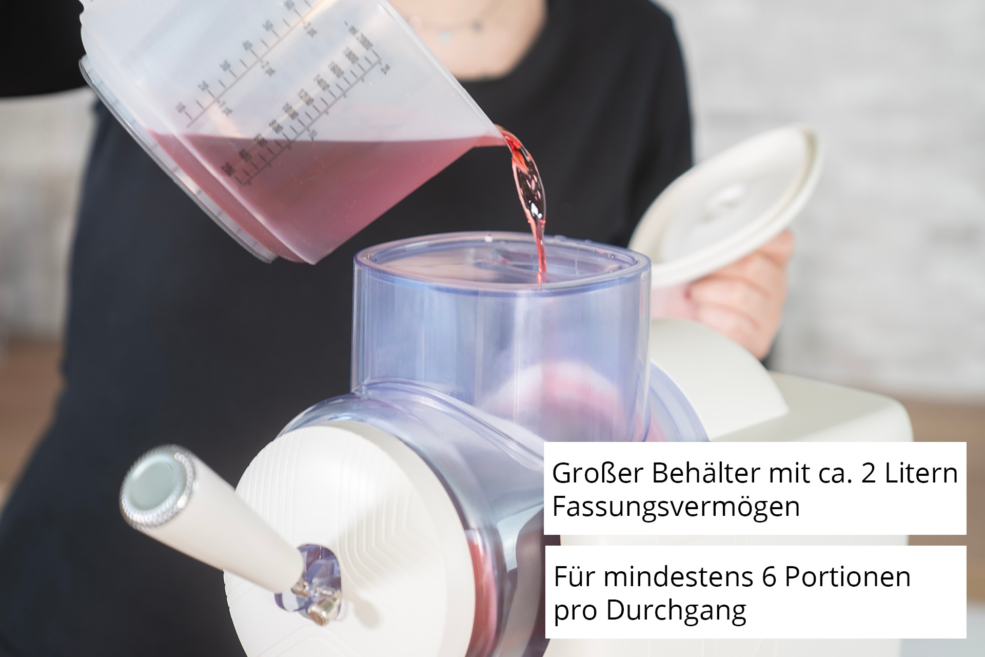 Eine Person gießt rote Flüssigkeit in eine Eismaschine. Text auf Deutsch ist sichtbar.