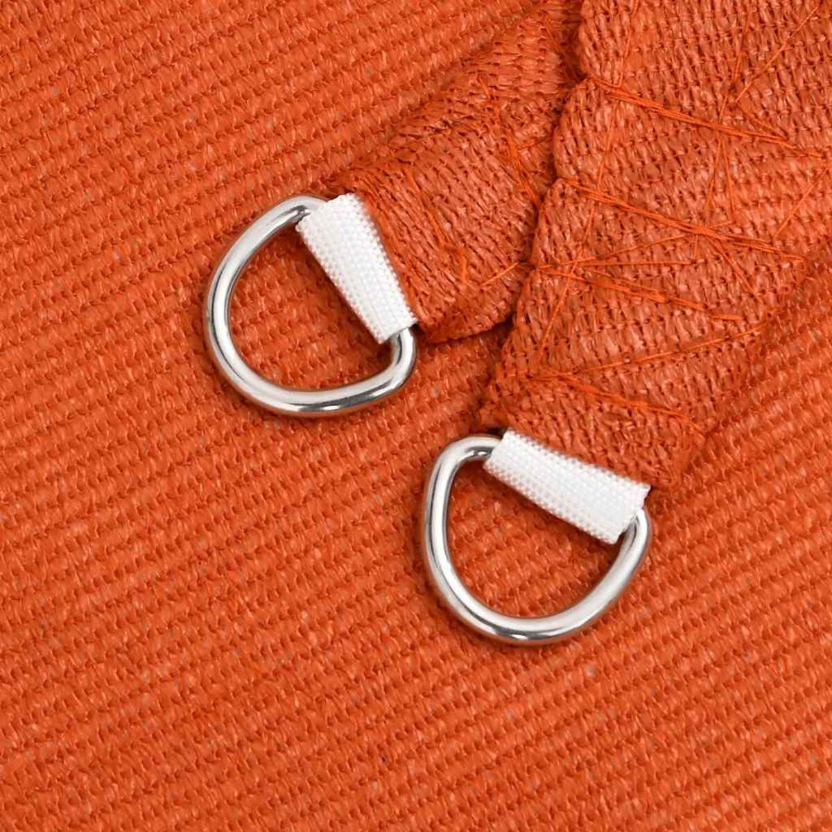 Nahaufnahme eines orangefarbenen Stoffes mit zwei silbernen D-Ringen, die mit weißen Riemen befestigt sind.