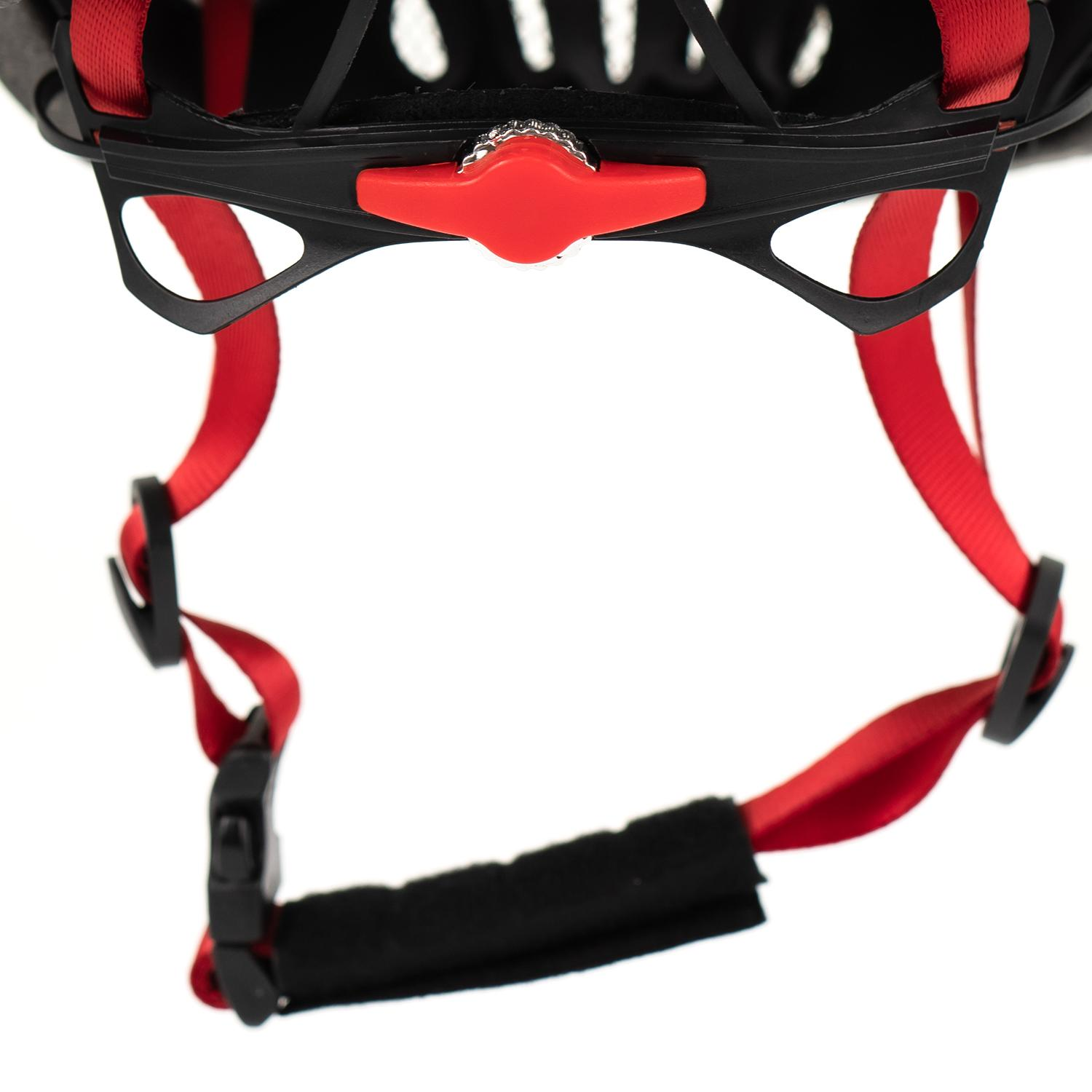 Primer plano de un casco, mostrando correas rojas y mecanismo de ajuste.
