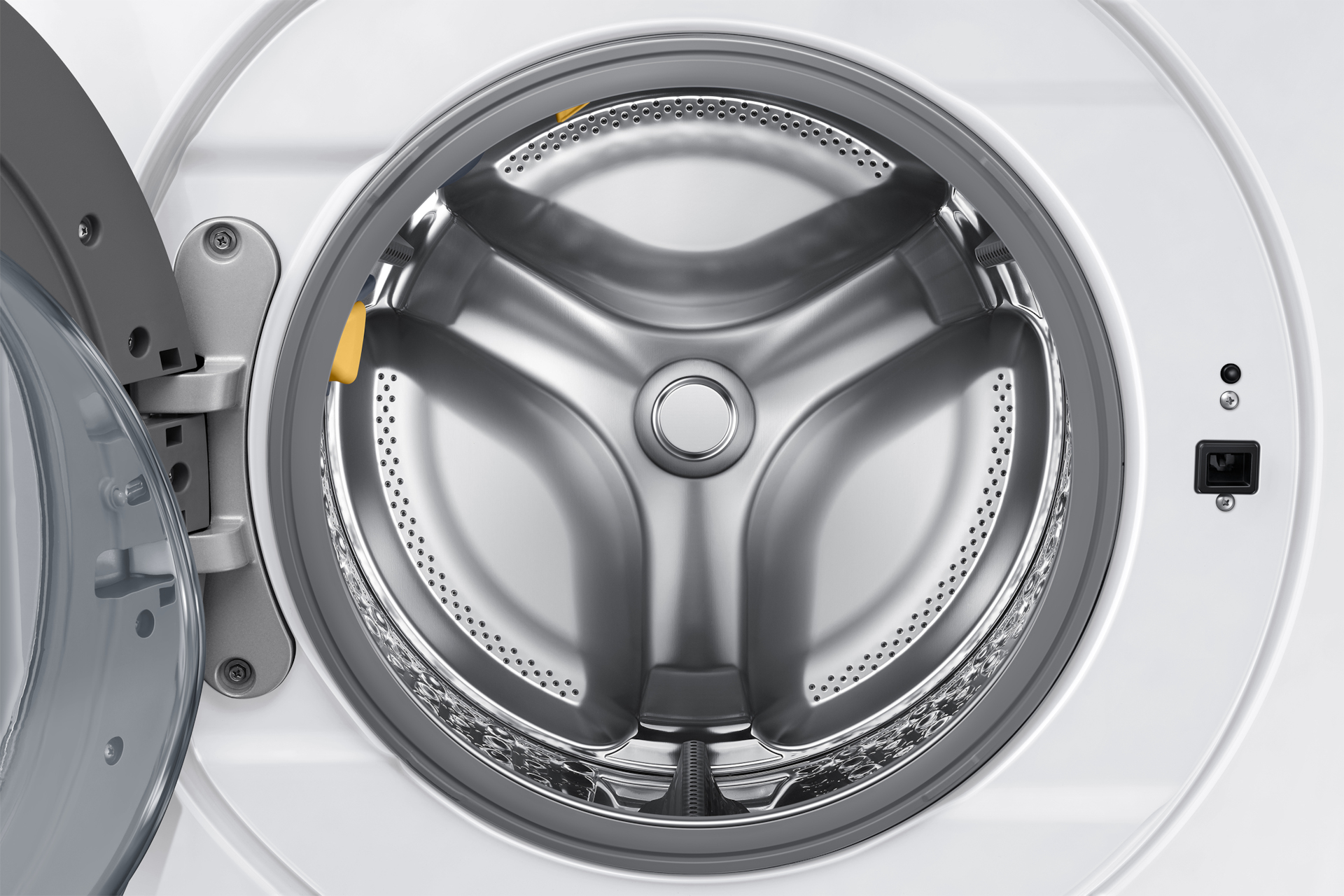 Bęben pralki ze srebrnym wnętrzem ma trzy równomiernie rozmieszczone listwy i małe otwory.