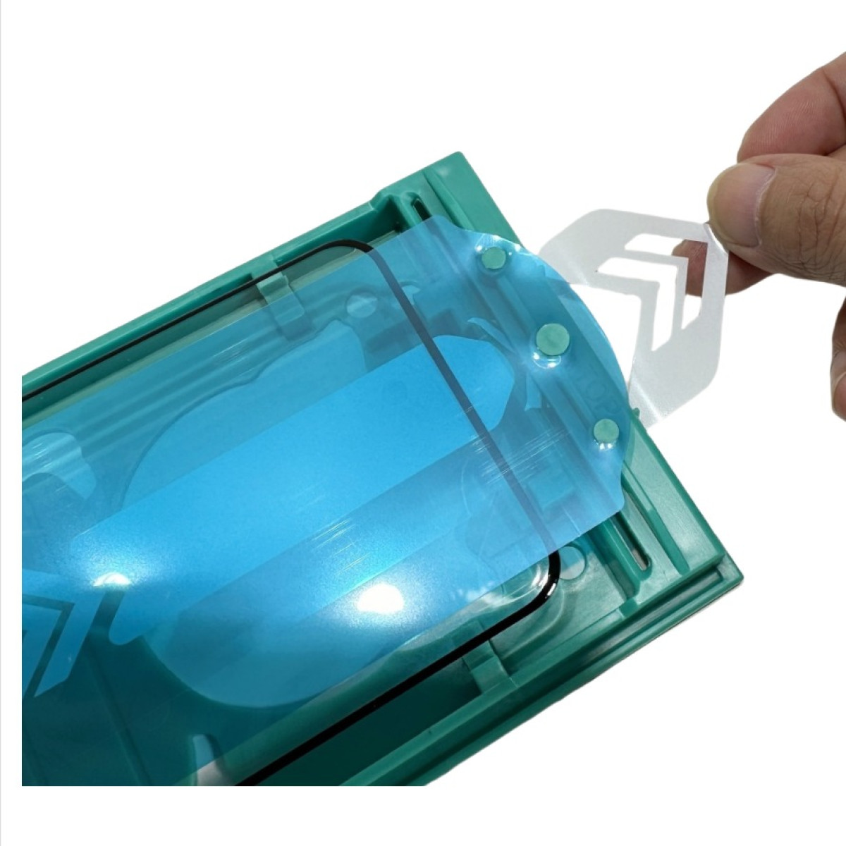 Mano che stacca la protezione schermo. Pellicola blu sullo schermo. Supporto verde. Sfondo bianco.