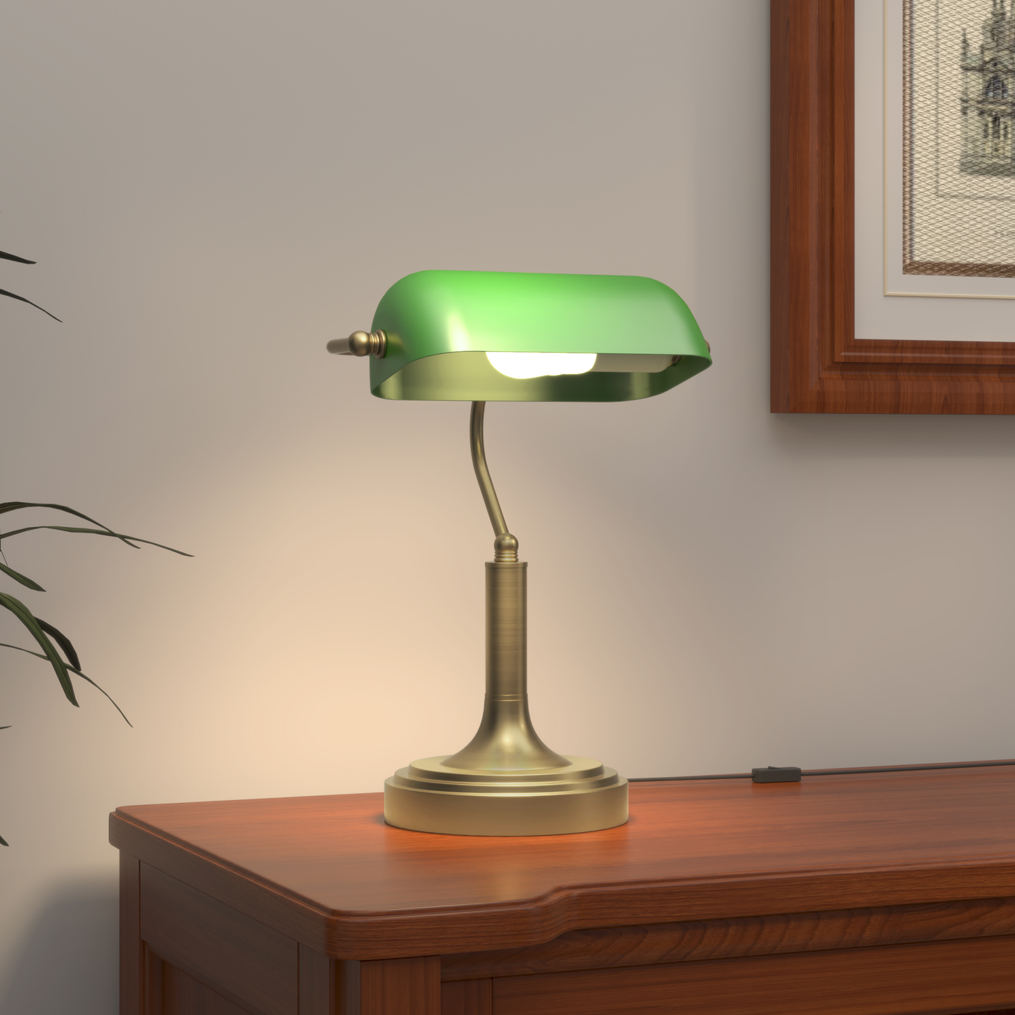 Lámpara de banquero verde sobre un escritorio de madera. La lámpara está encendida y cerca de una pared con una imagen.