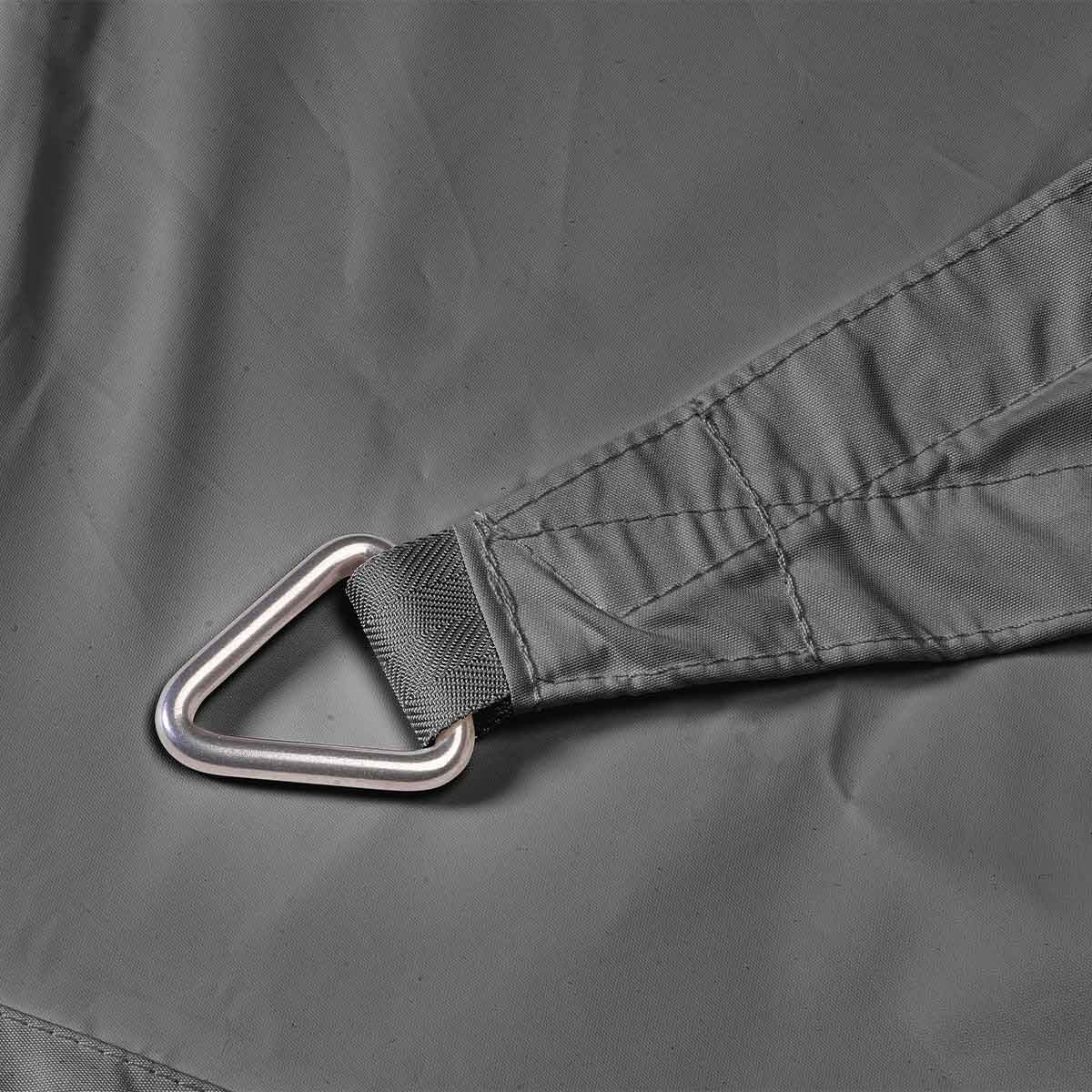 Un tissu gris possède un anneau métallique fixé à son coin, sous une lumière vive.