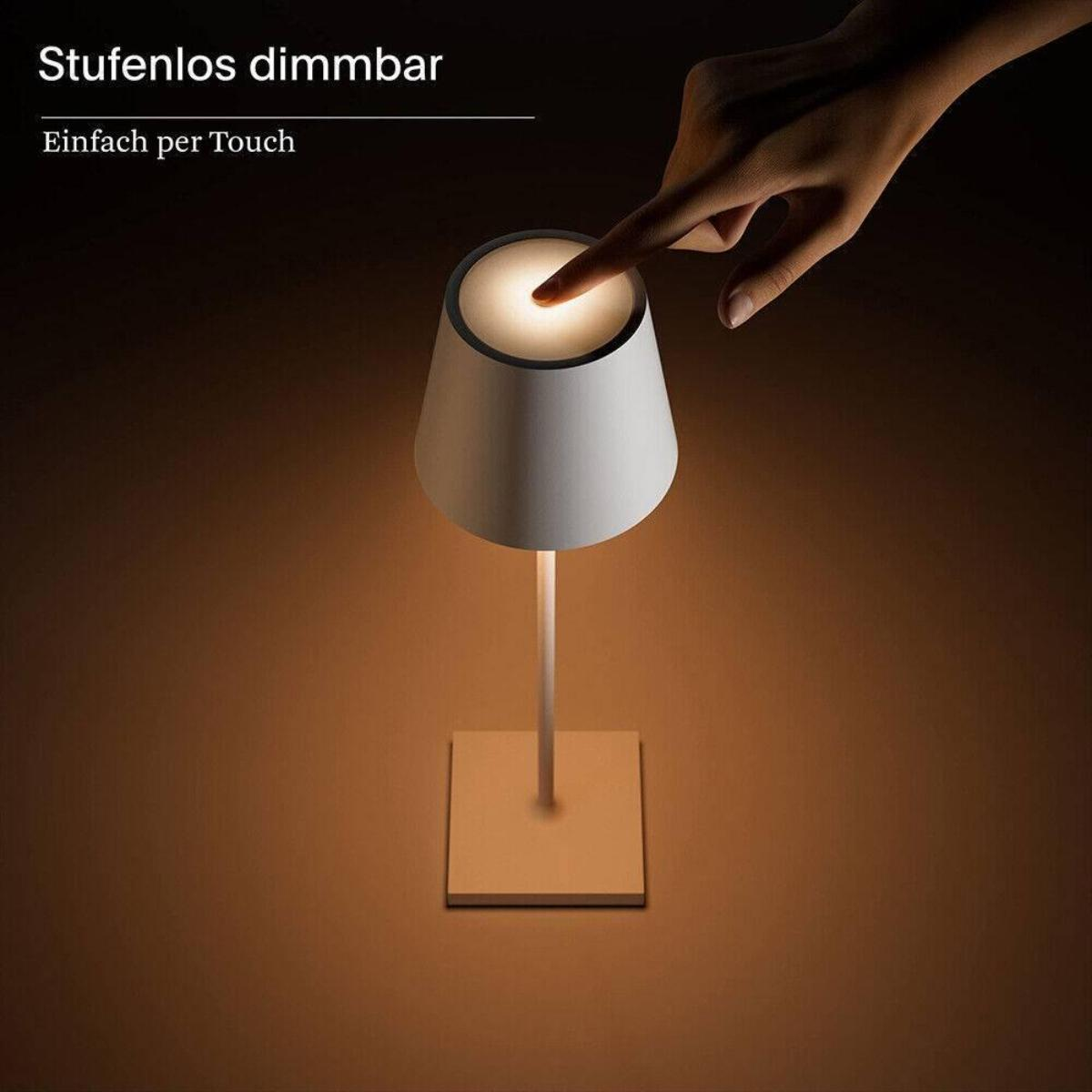 Die Hand einer Person berührt eine Lampe. Die Lampe ist weiß und hat einen quadratischen Sockel.
