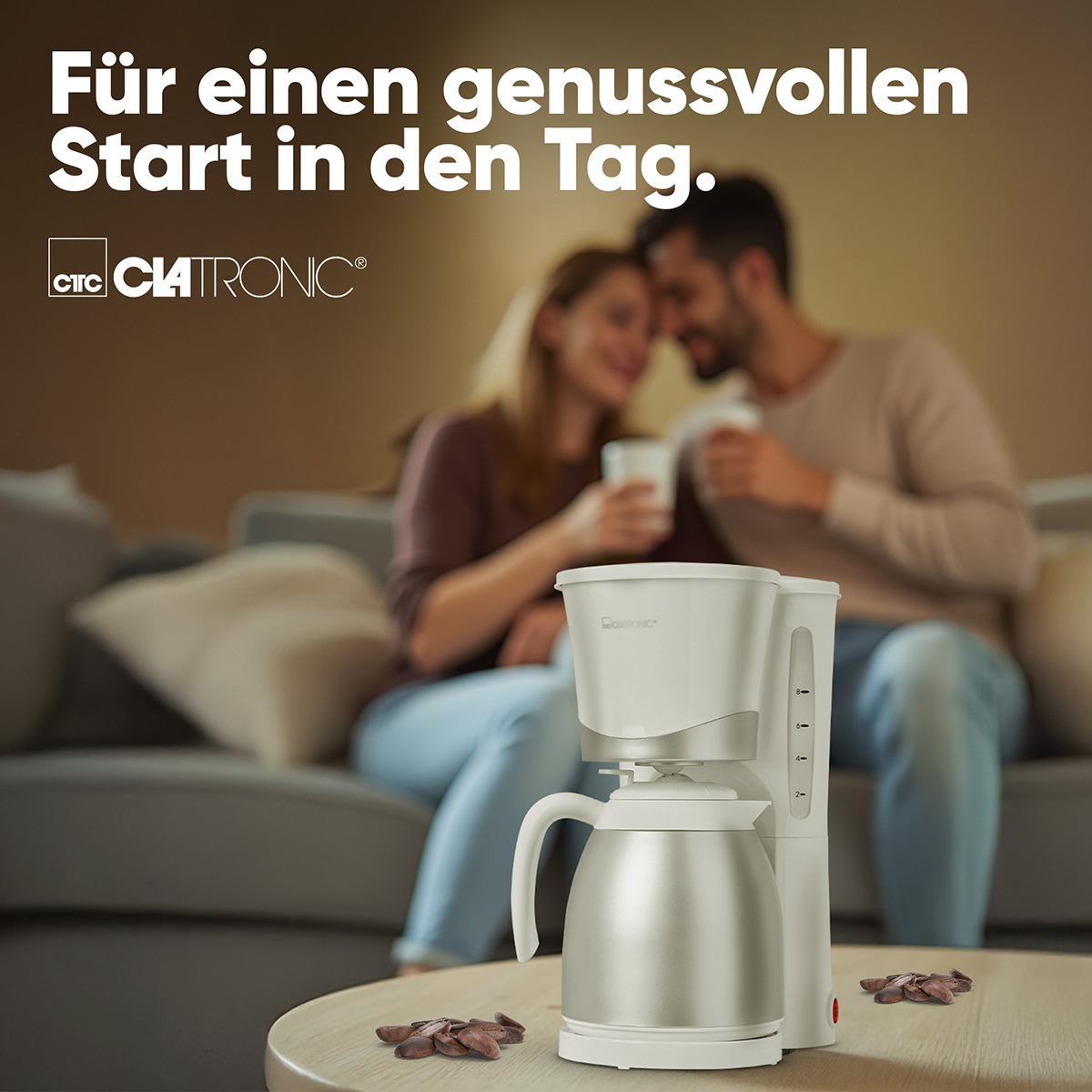 Biało-srebrny ekspres do kawy Clatronic na drewnianym stole z parą w tle.