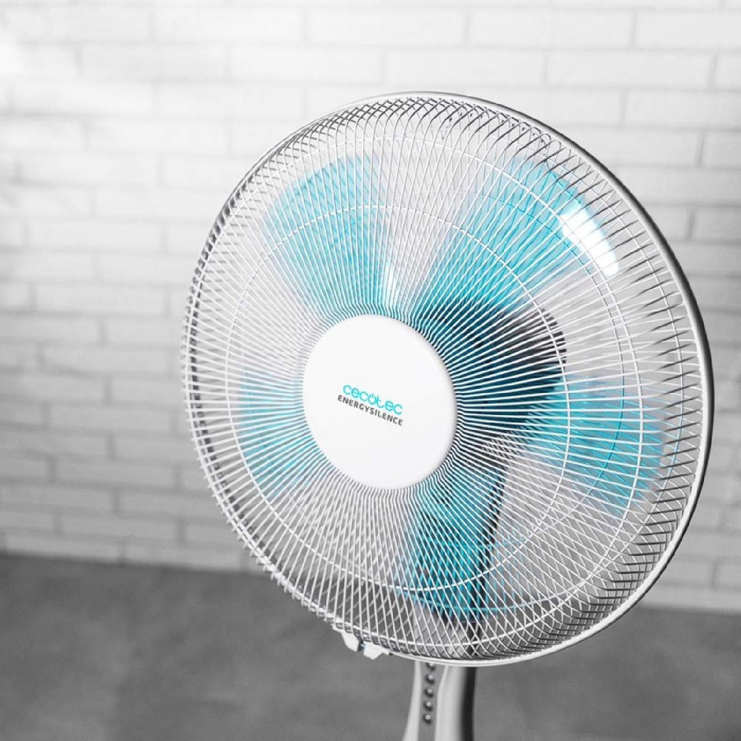 Biało-niebieski wentylator z napisem ENERGY SILENCE. Ceglana ściana w tle.