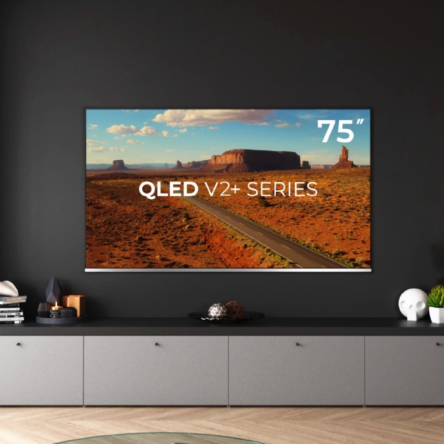 Uno schermo TV che mostra un'immagine di un paesaggio. Un mobile e decorazioni in primo piano.