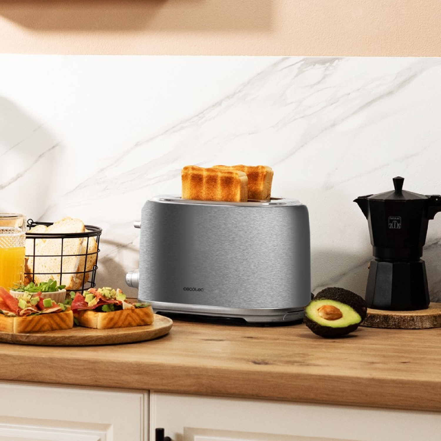 Srebrny toster z tostami w środku. Awokado, tosty z dodatkami i ekspres do kawy na blacie.