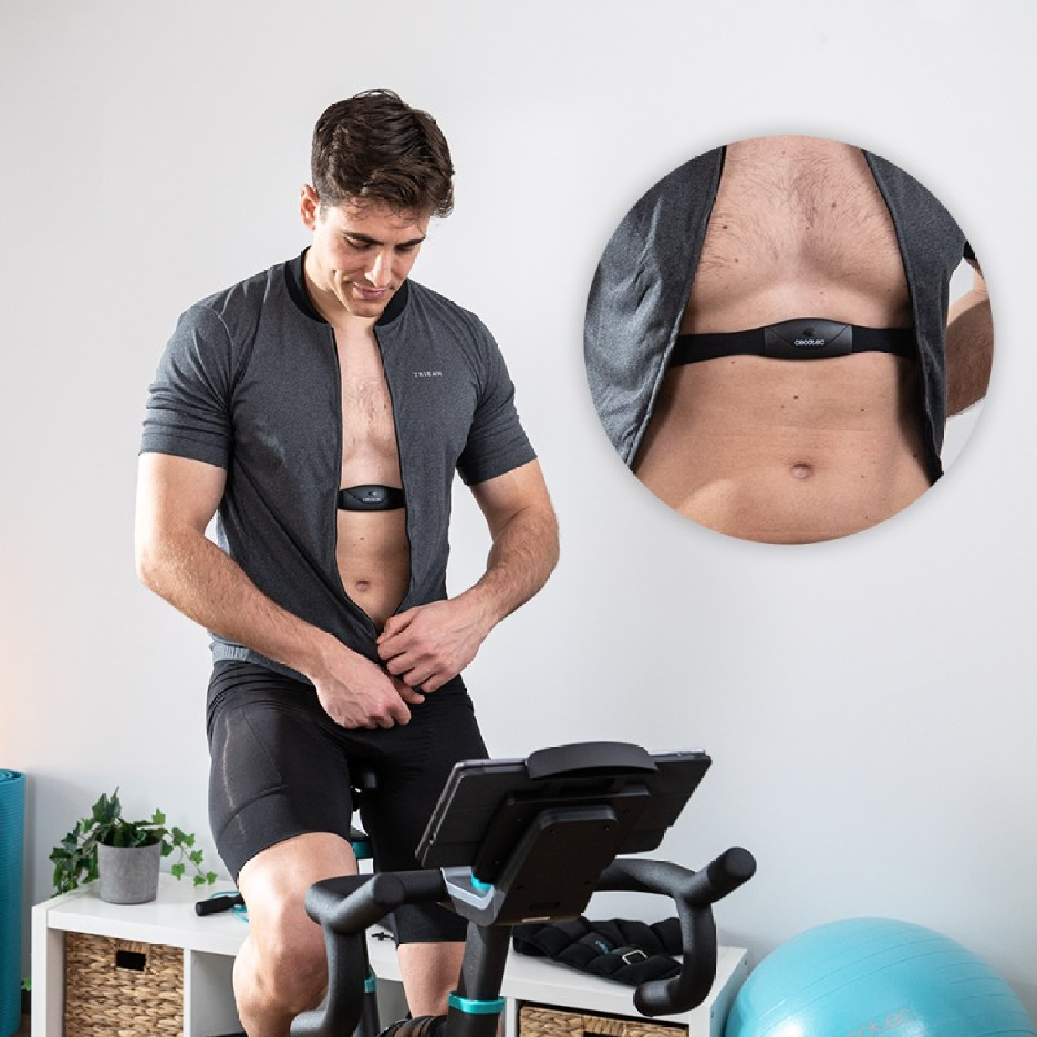 Uomo in maglia grigia con cardiofrequenzimetro sulla cyclette.