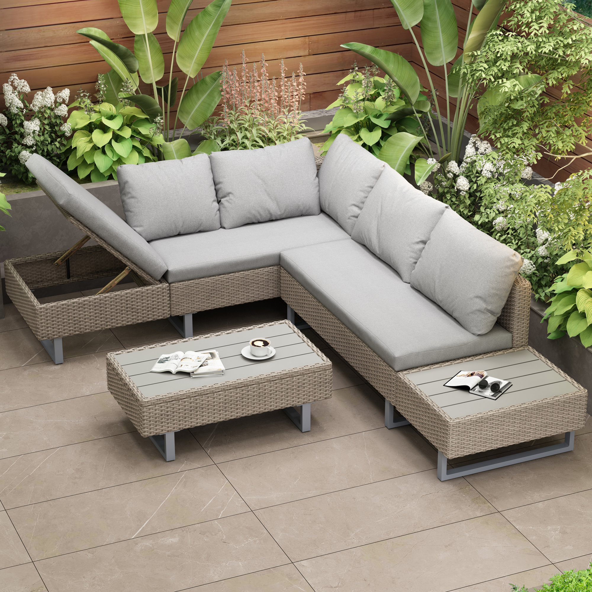 Terrassenmöbel. Graue Sofas und Couchtische. Grüne Pflanzen und Holzzaun.