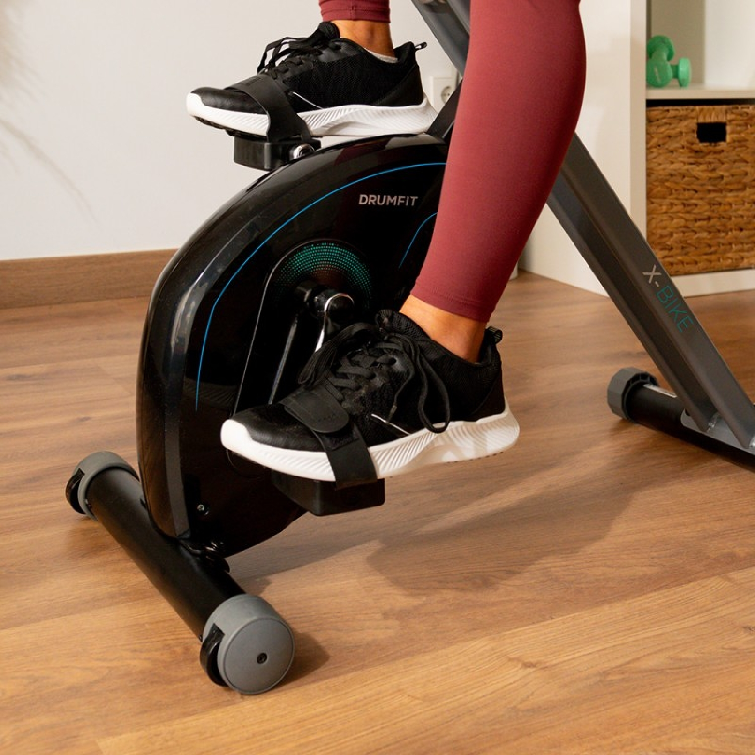 Kobieta na rowerze stacjonarnym. Zbliżenie na stopy i rower.