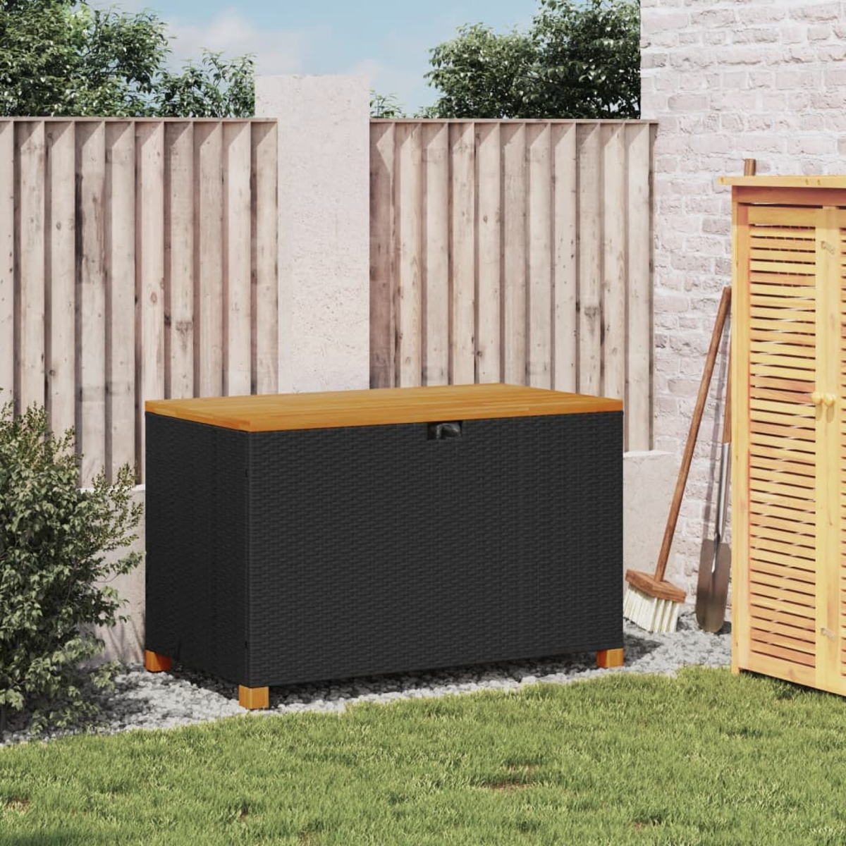 Aufbewahrungsbox mit Holzplatte und gewebten Seiten, auf Gras, Zaun im Hintergrund.