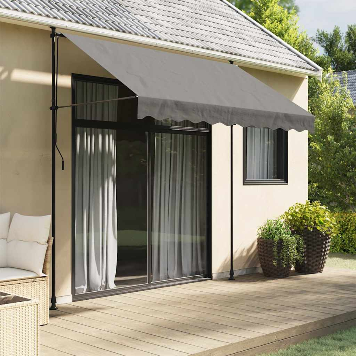 Ein Haus mit grauem Vordach über einer Tür und einer Holzterrasse. Pflanzen sind sichtbar.