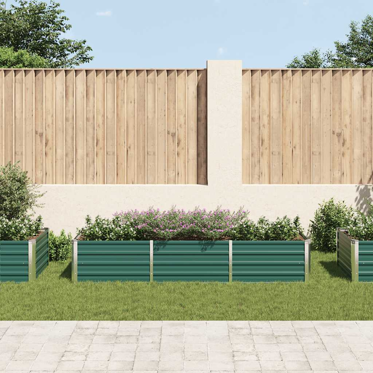 Gartenbeet mit grünen Metallseiten. Pflanzen und Blumen innen. Holzzaun im Hintergrund.