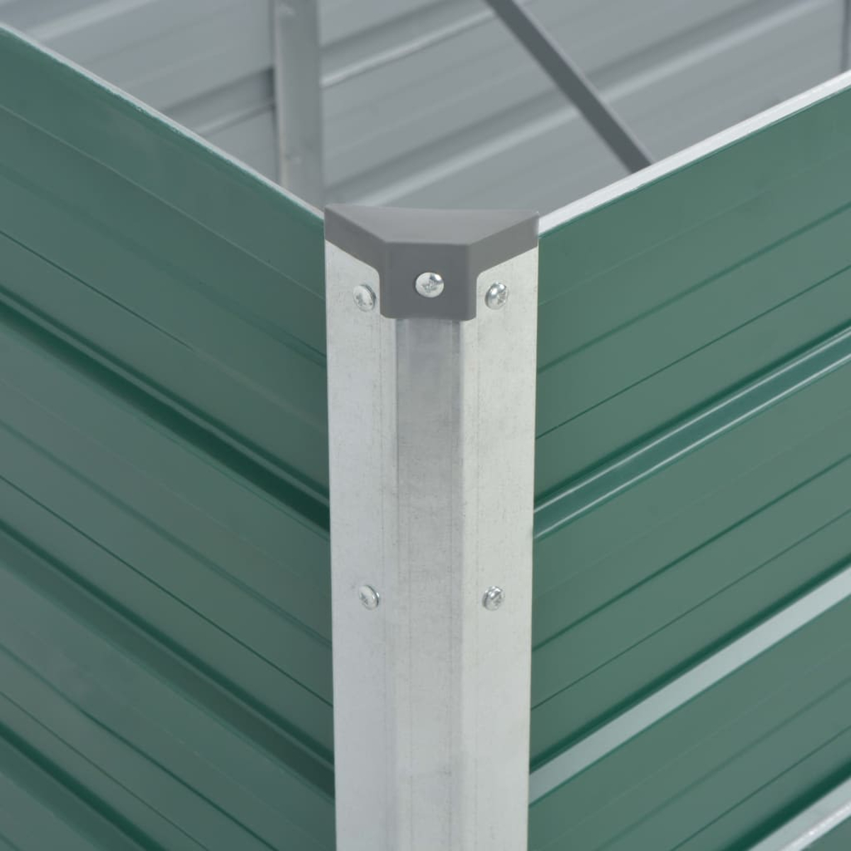 Nahaufnahme der Ecke eines grünen Metall-Hochbeets mit grauer Eckabdeckung.