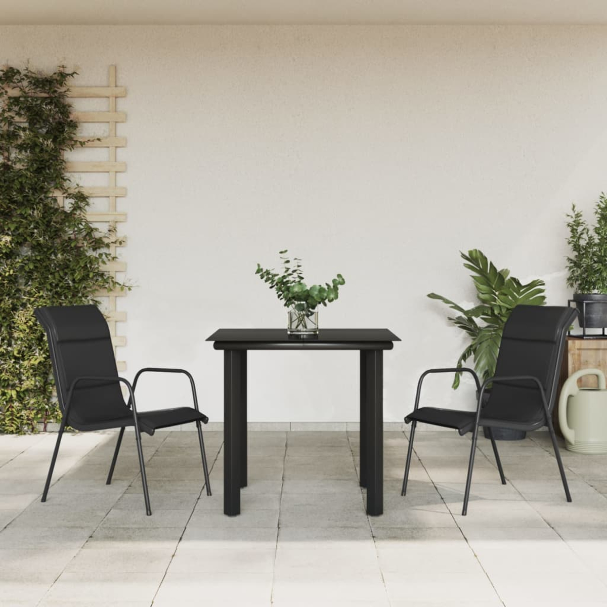 Szene im Freien mit schwarzem Tisch, Stühlen und Pflanzen.