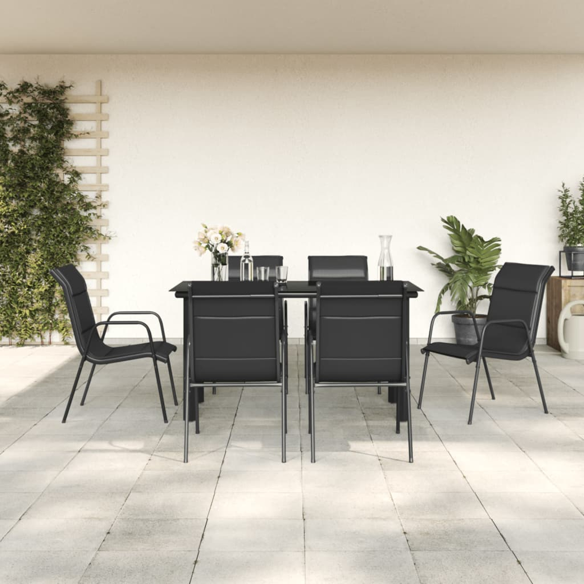Essgruppe im Freien: schwarzer Tisch und Stühle, Terrasseneinstellung, weiße Wand.
