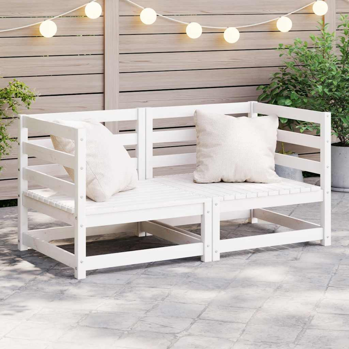Weiße Holz-Sitzgelegenheit im Freien mit Kissen. Einheit hat Lamellendesign auf einer Terrasse mit Lichtern.