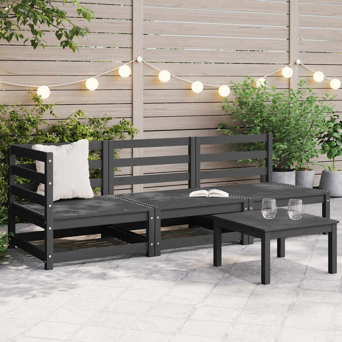Eine Terrassengarnitur mit Sofa, zwei Stühlen und einem Tisch. Das Set ist dunkelgrau mit Holzzaun im Hintergrund.