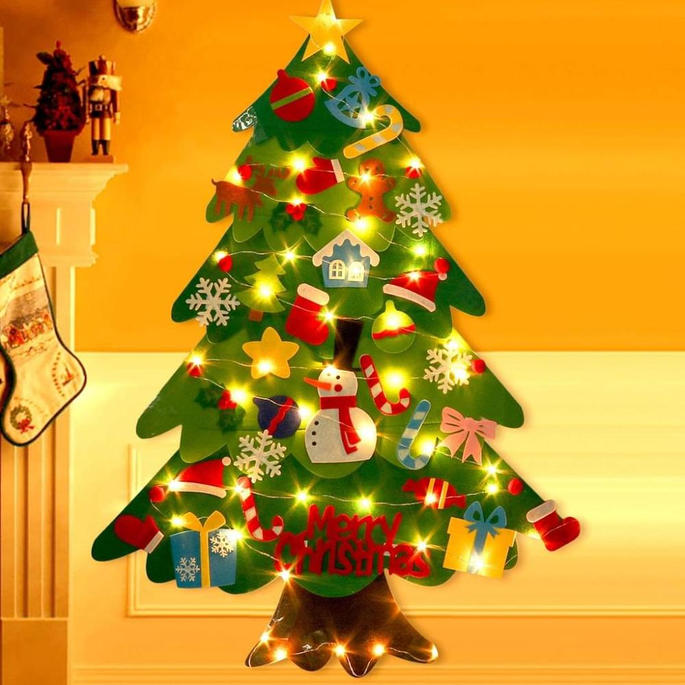 Grüner Filz-Weihnachtsbaum mit Ornamenten, Lichtern und einem Stern. Hintergrund: Kamin und Strumpf.