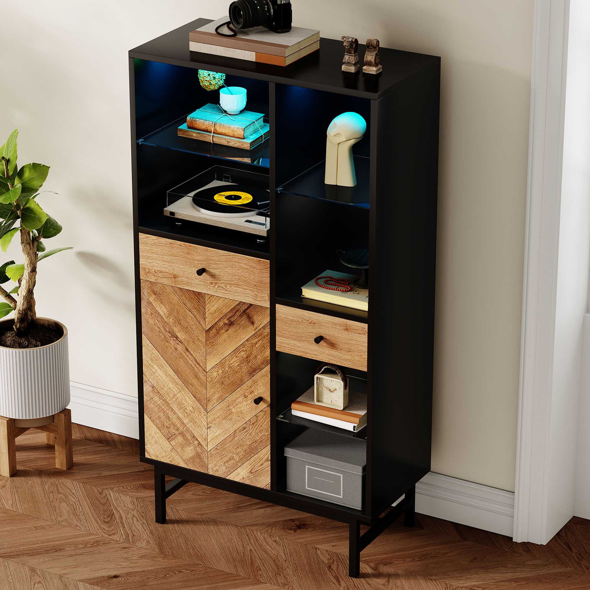 Ein schwarzer und hölzerner Schrank mit Regalen. Auf den Regalen befinden sich eine Kamera, Bücher und ein Plattenspieler.