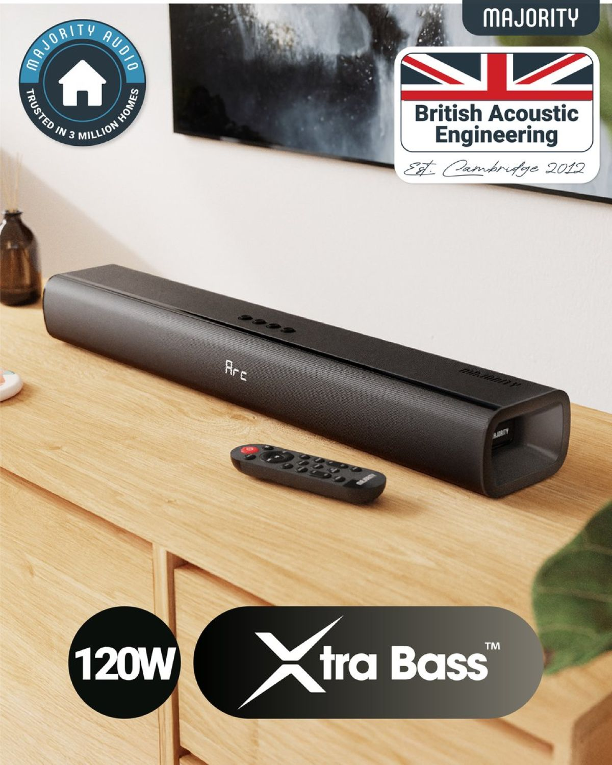 Soundbar on wooden cabinet. Remote control in front. 'British Acoustic Engineering' badge.