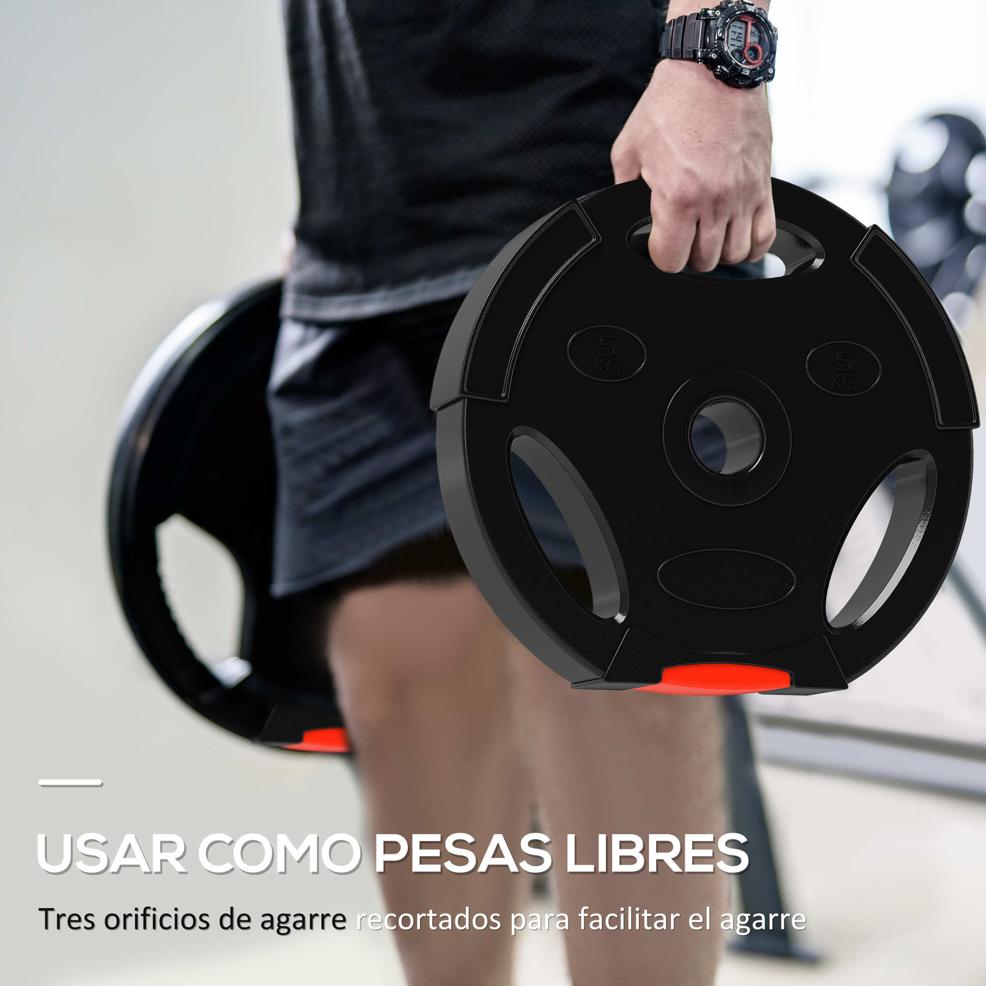 Un hombre sosteniendo un disco de pesas negro con tres agujeros. El disco tiene detalles en rojo y un gimnasio en el fondo.