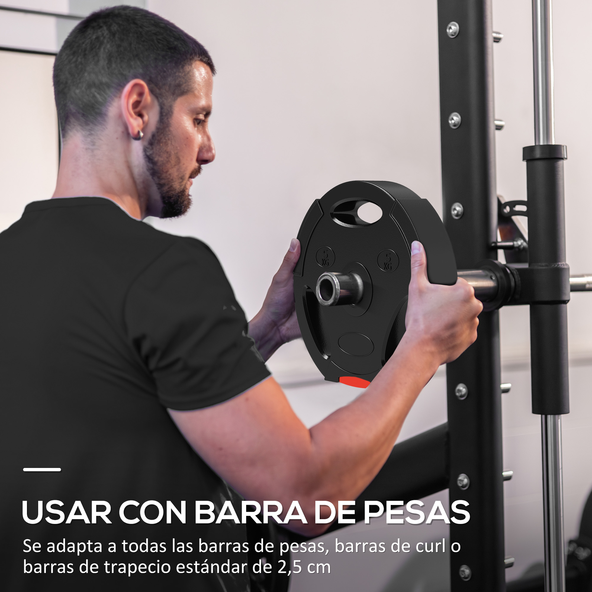 Un hombre está poniendo un disco de pesas en una barra. El disco es negro con un acento rojo. El gimnasio está al fondo.