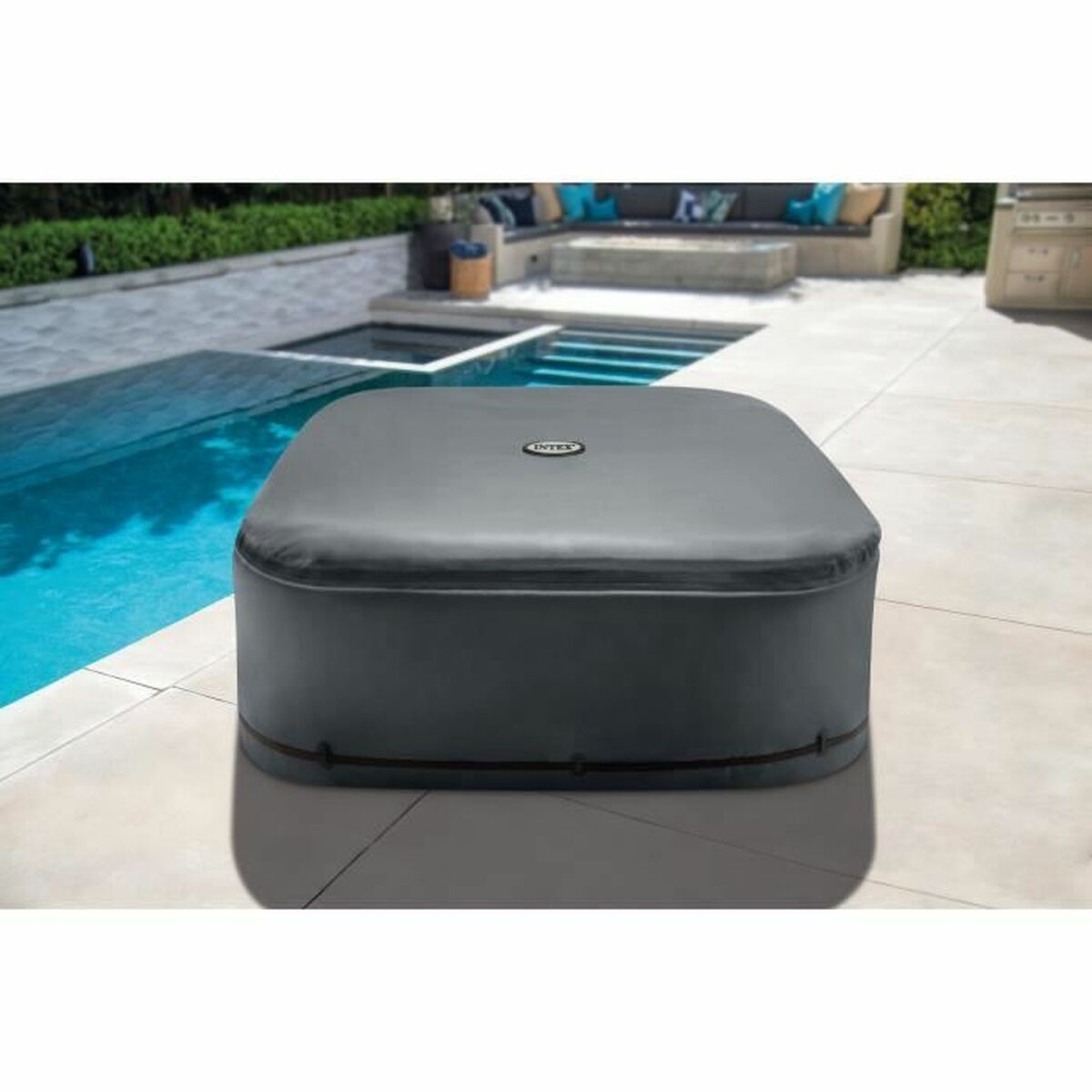 Dunkelgrauer, quadratischer Whirlpool mit Deckel. Pool und Garten im Hintergrund.